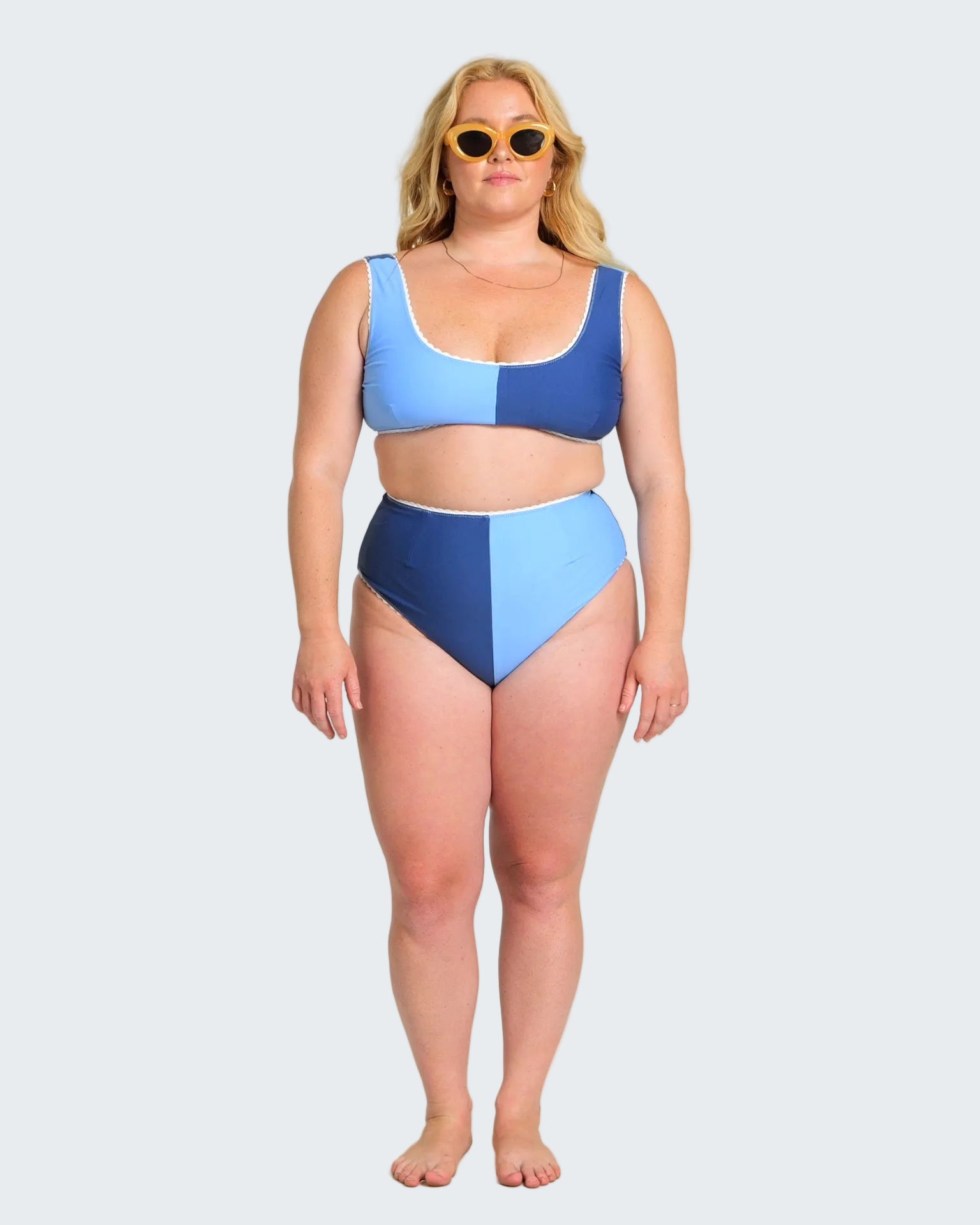 Woman wearing a blue and navy two-piece swimsuit on a white background