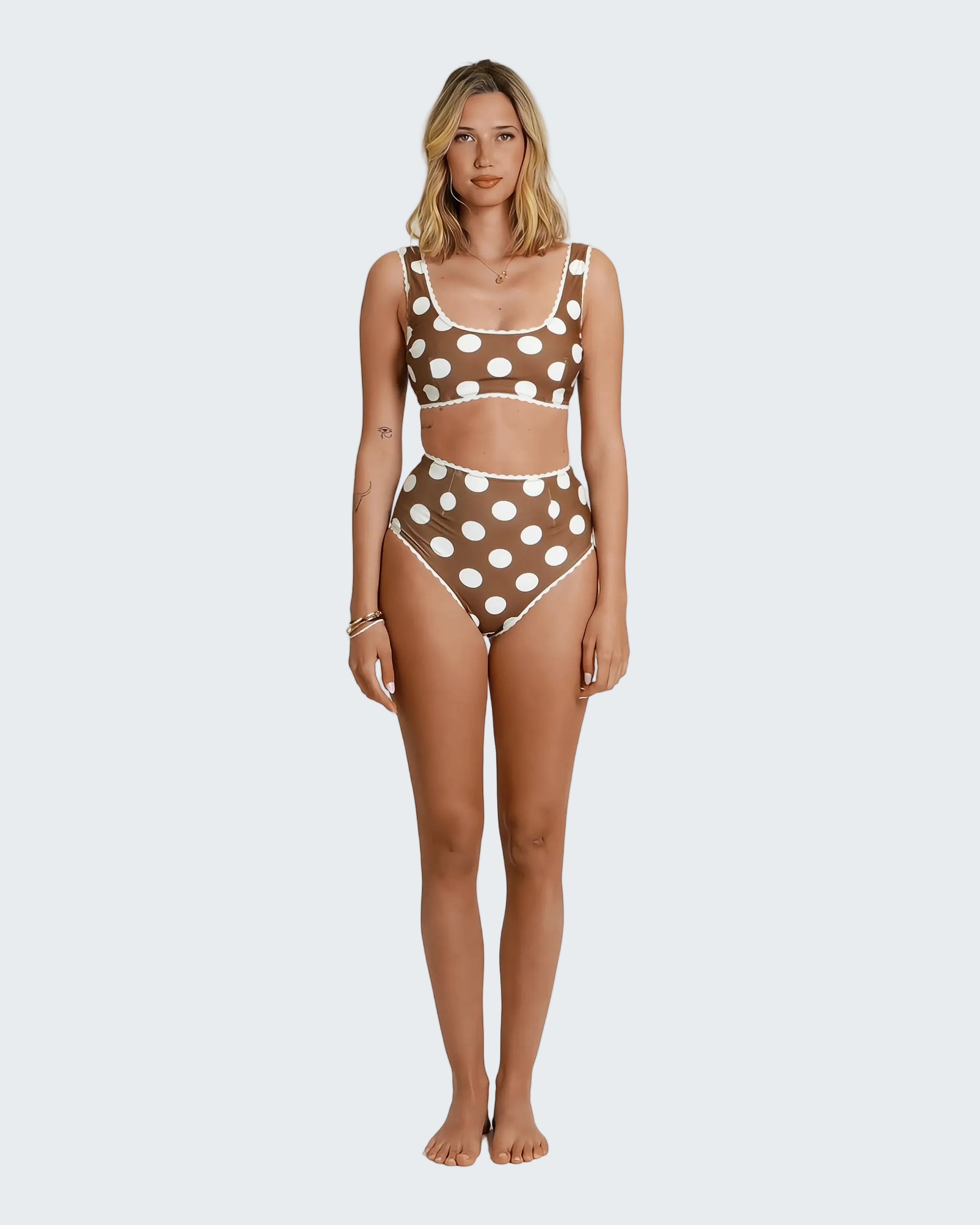 Woman wearing a brown polka dot bikini set on a white background