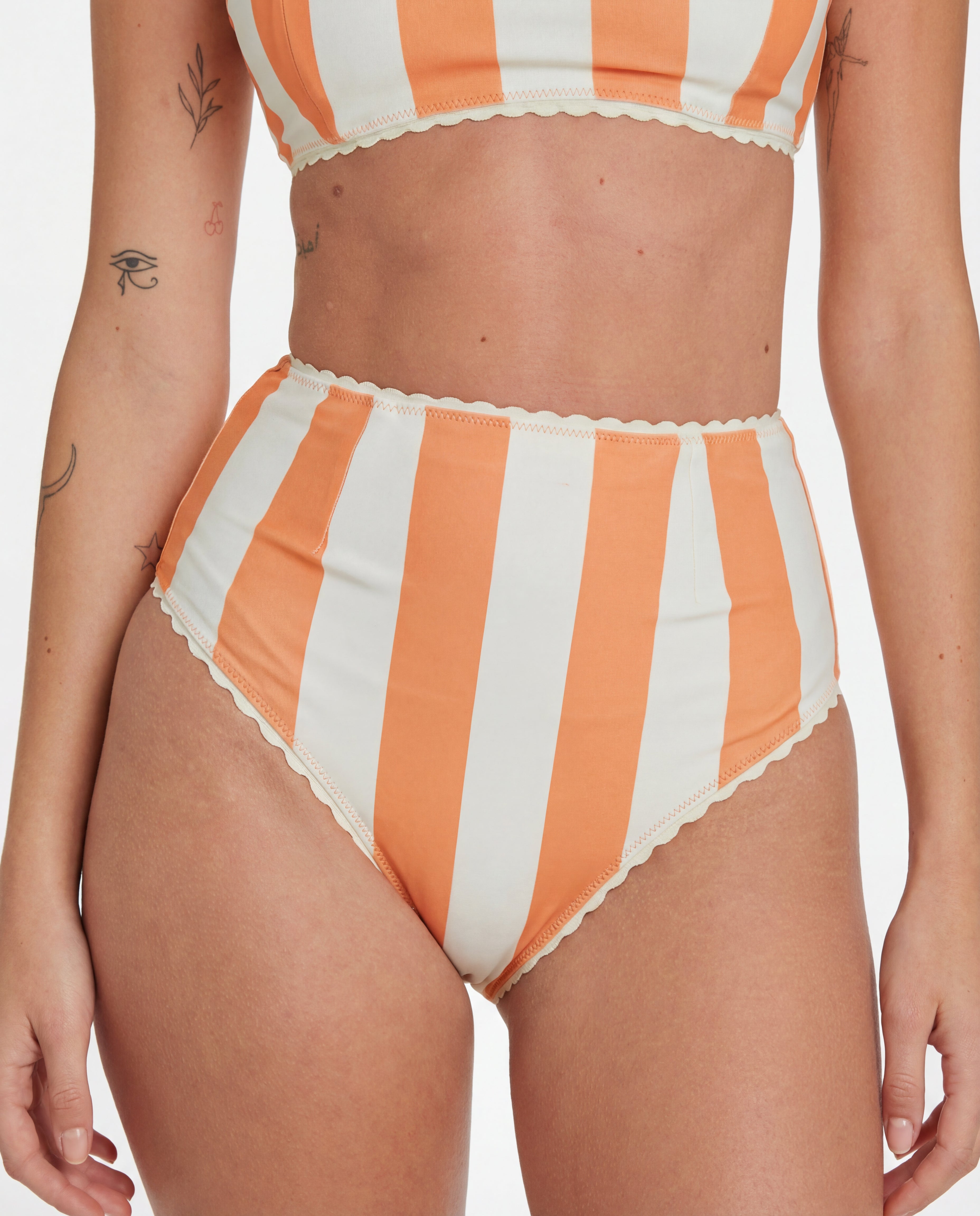 Orange and white striped bikini set on a plain background