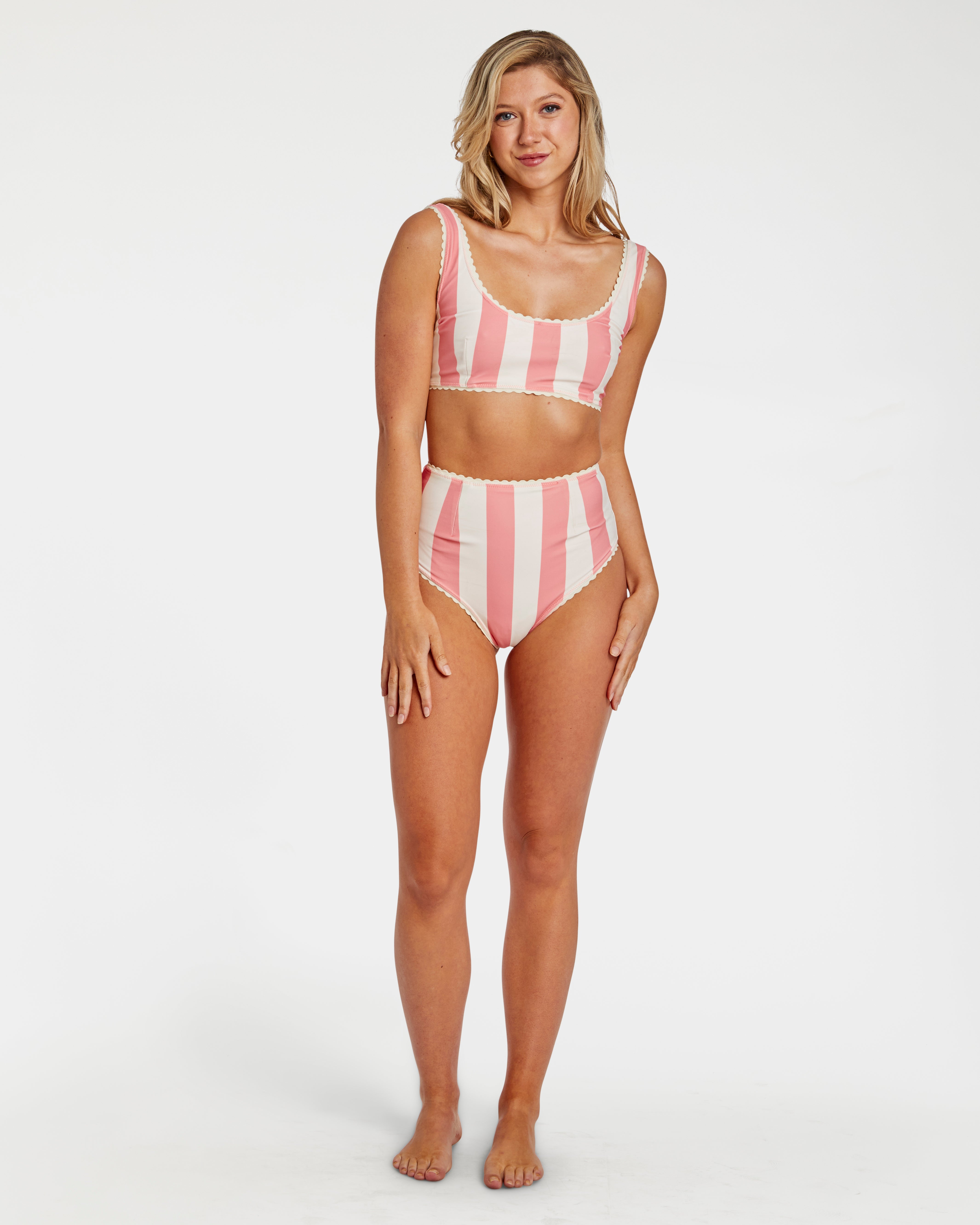 Woman wearing a pink and white striped bikini on a white background