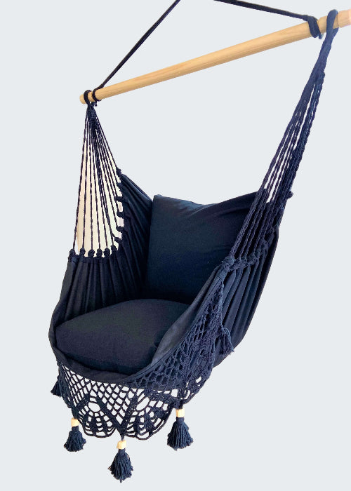 Navy blue hammock chair with tassels in a room setting.