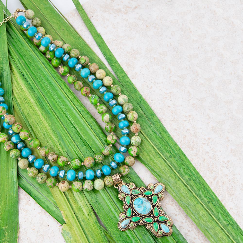 Necklace with blue and green beads and a decorative clasp on green leaves.