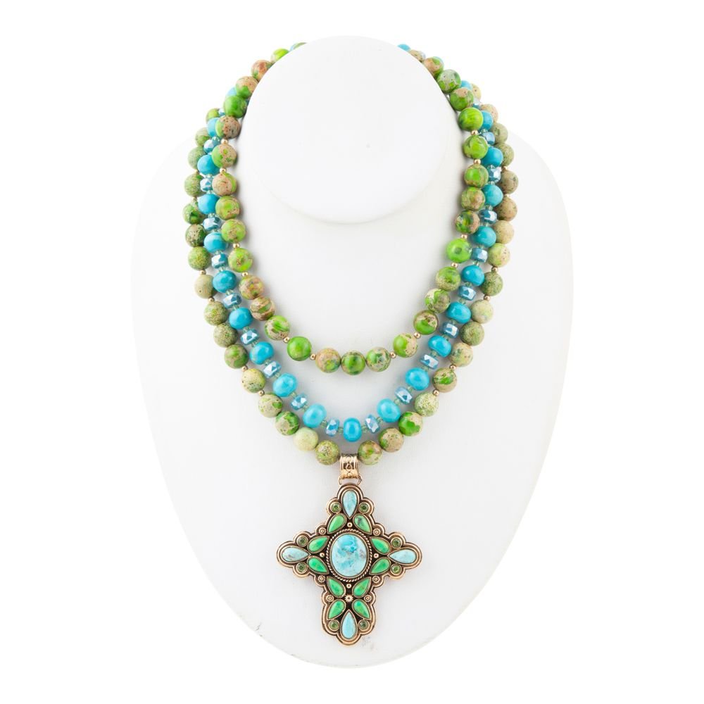 Necklace with green and blue beads on a white stand