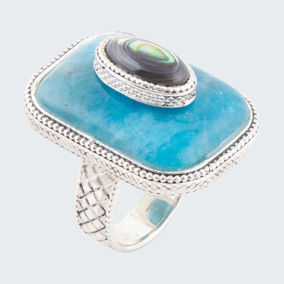 Ring with blue stone and silver band on a white background