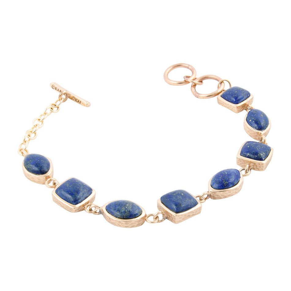 Gold bracelet with blue stones on a white background