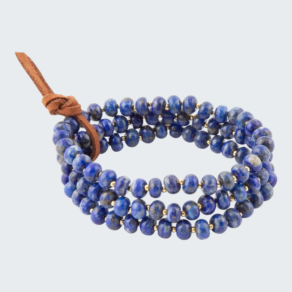 Blue beaded bracelet with a brown leather strap on a white background