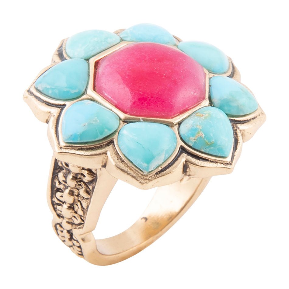 Ring with turquoise stones and a pink center on a white background