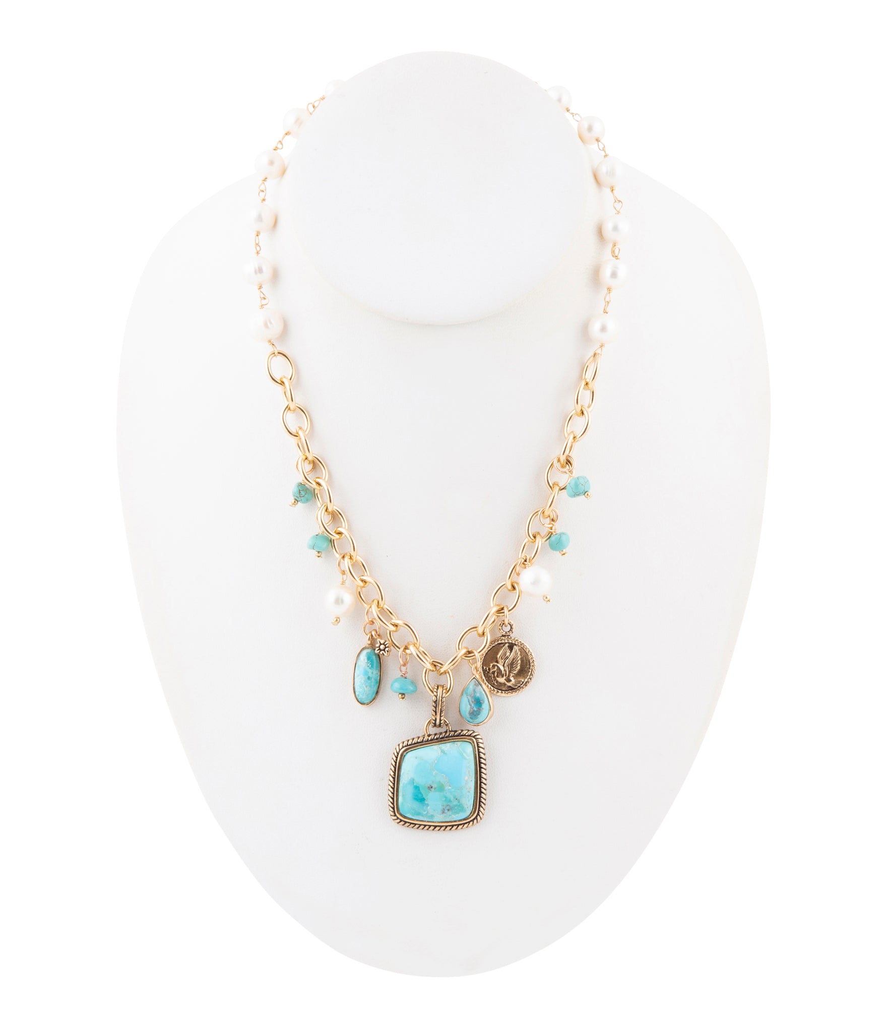 Gold necklace with turquoise pendant on a white stand