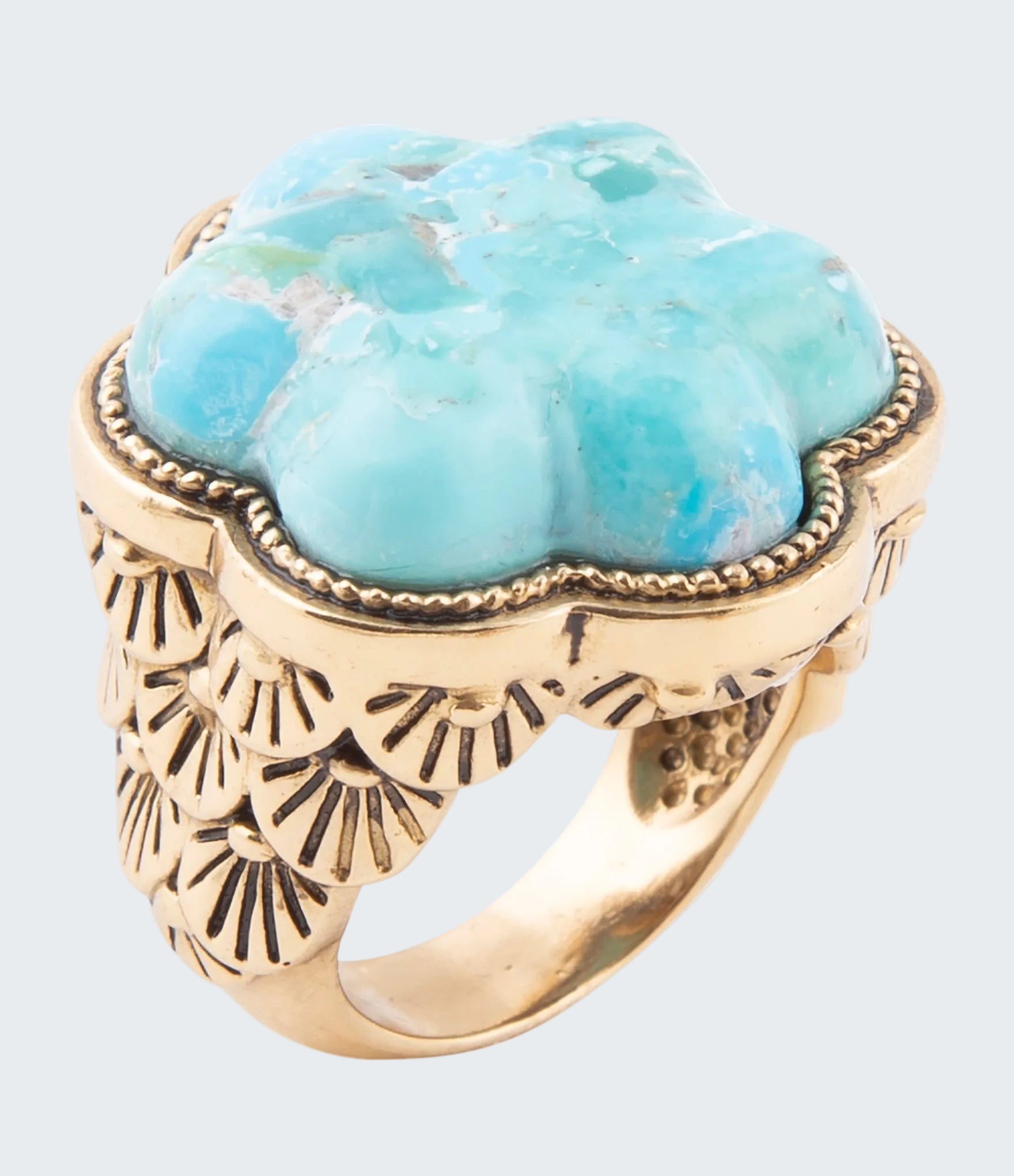Ring with turquoise stone and gold band on a white background
