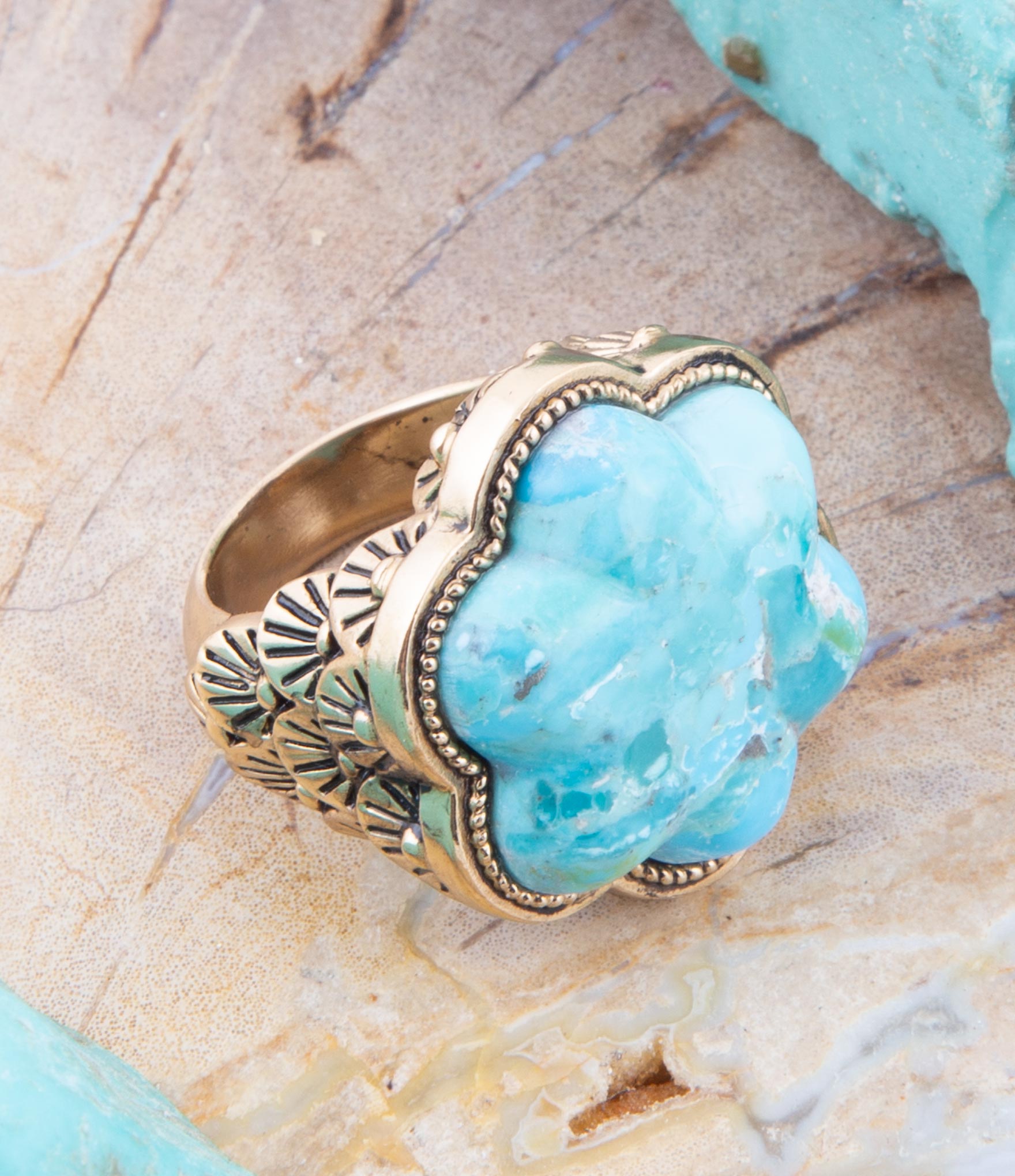 Turquoise stone ring with gold band on a wooden surface