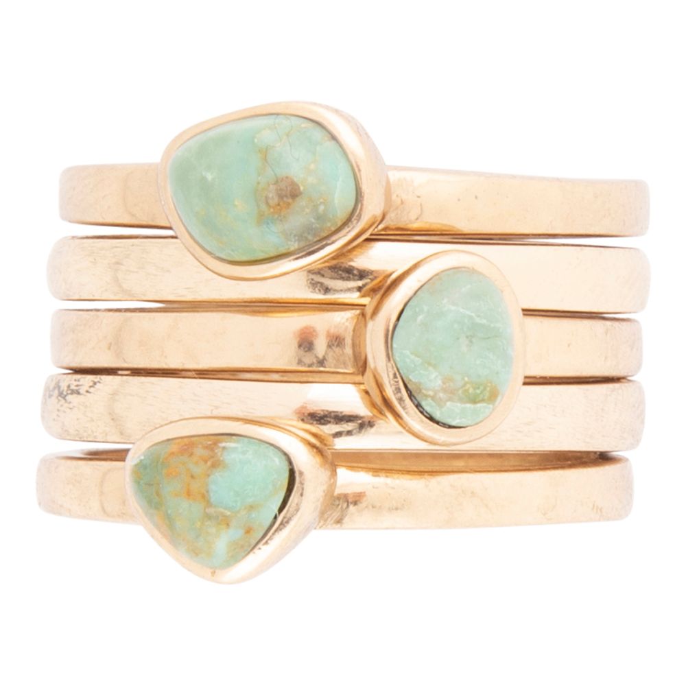 Set of gold rings with turquoise stones on a white background