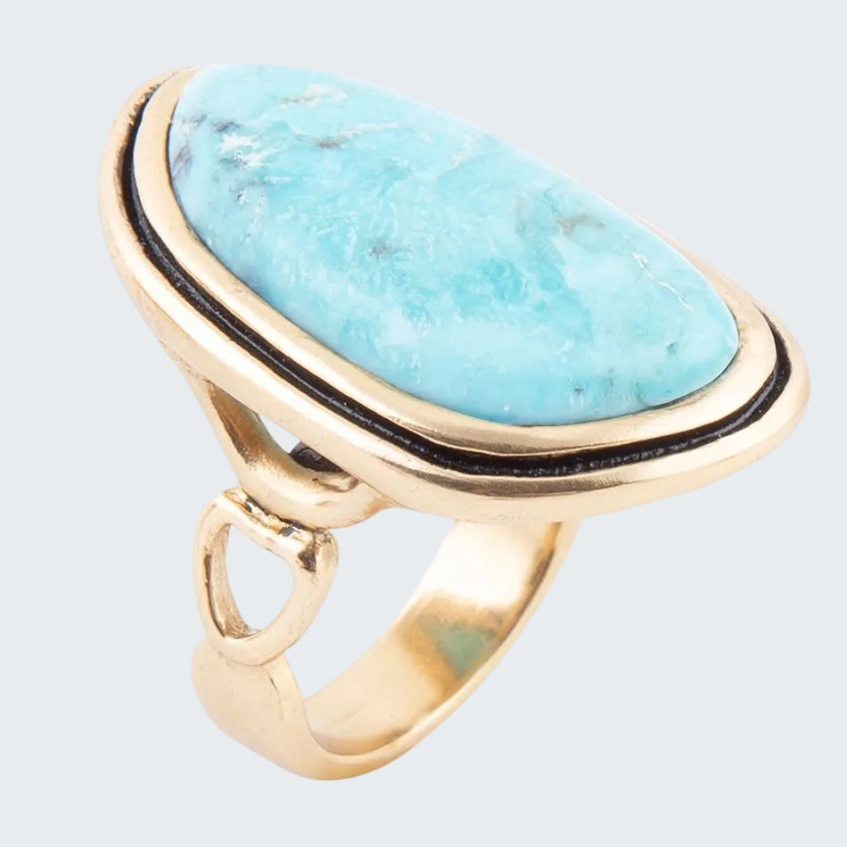 Gold ring with a large turquoise stone on a white background