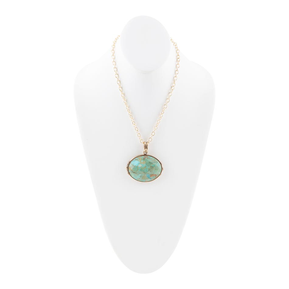 Necklace with a turquoise pendant on a white stand