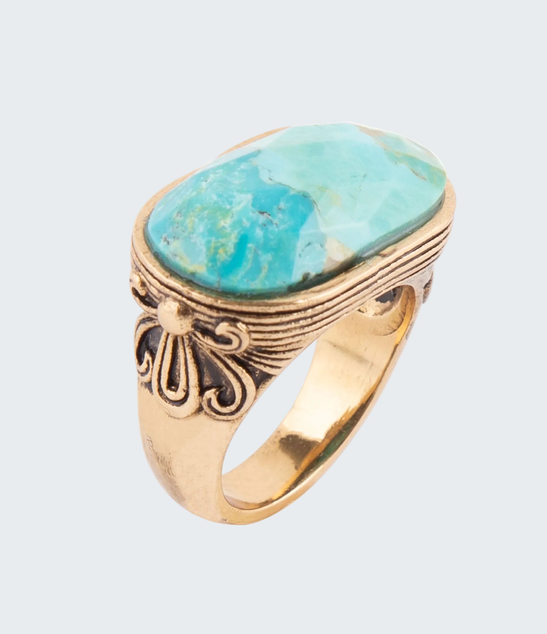 Gold ring with a large turquoise stone on a white background