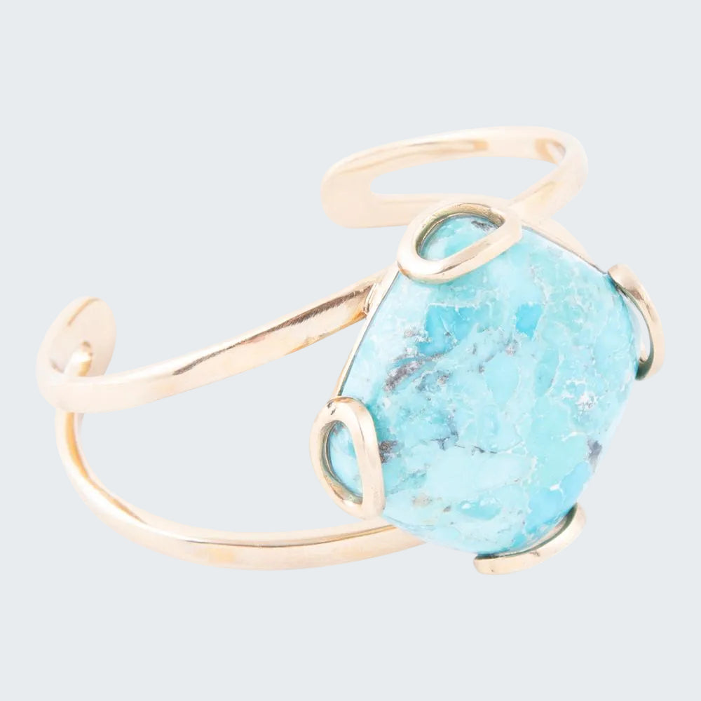 Turquoise stone ring with gold band on a white background