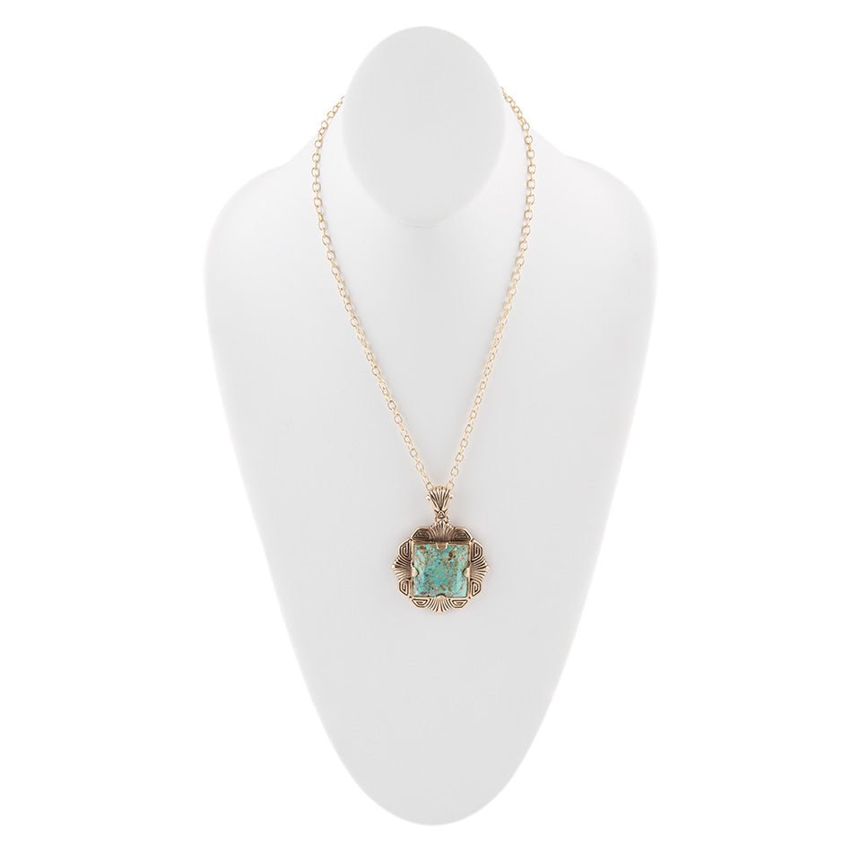 Necklace with a green pendant on a white mannequin bust