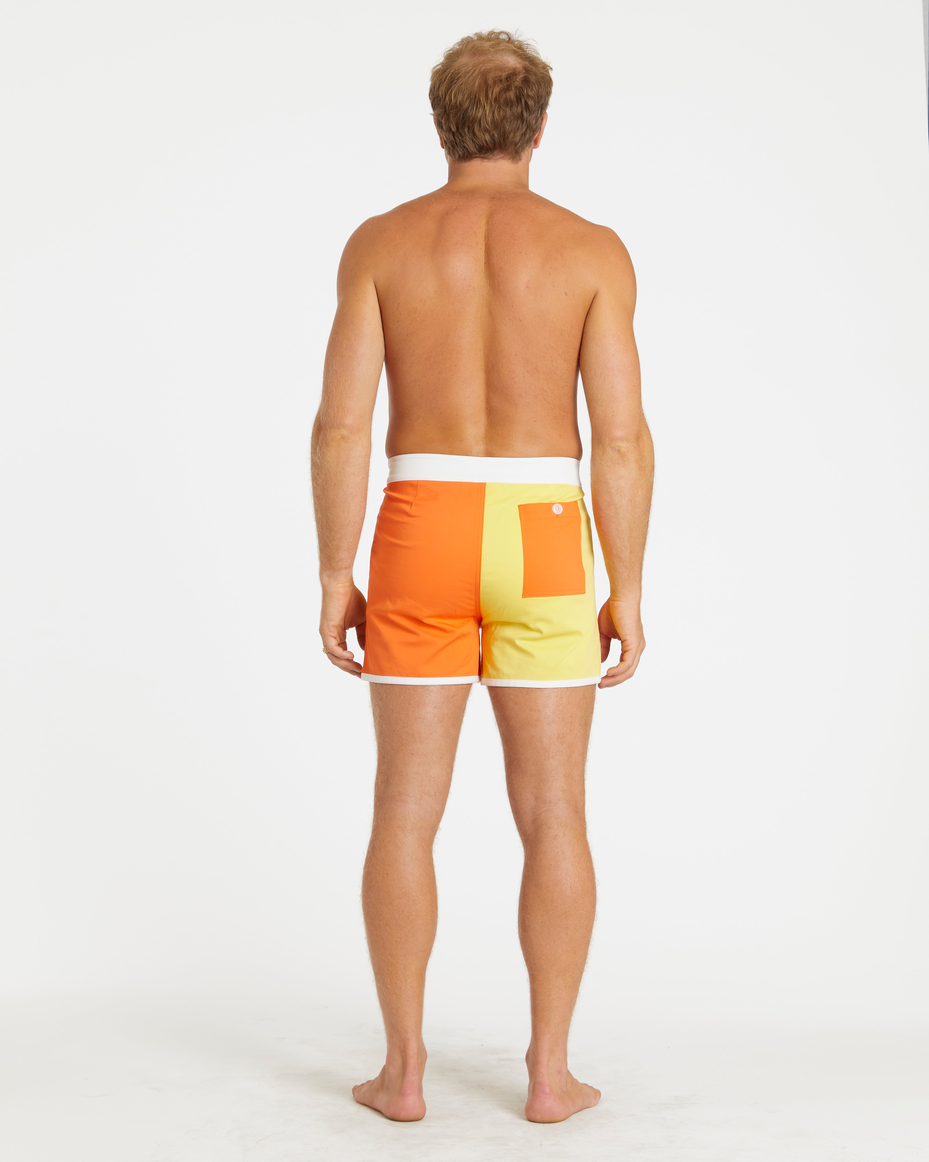 Man wearing a colorful swim trunks on a white background
