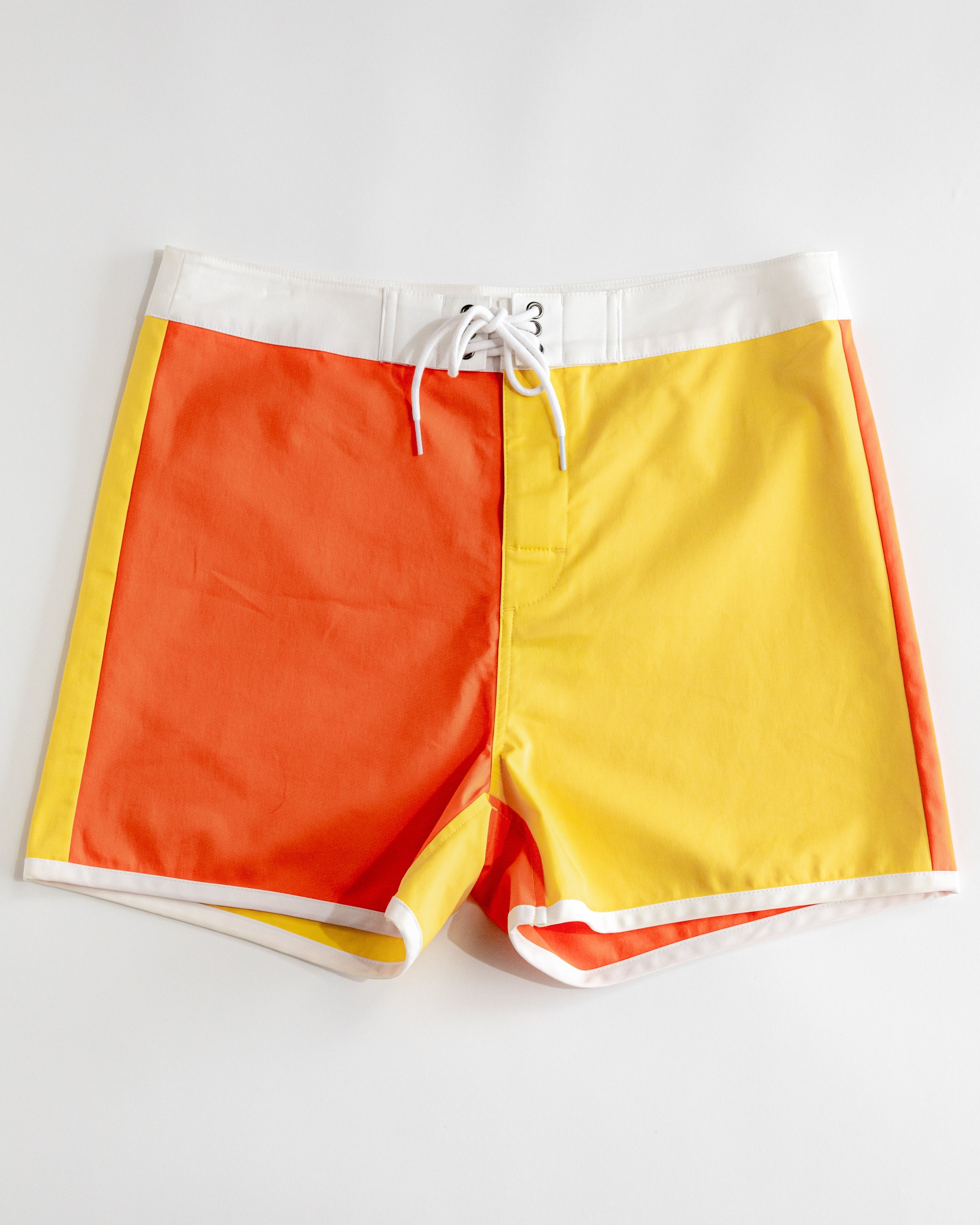 Color-blocked shorts with orange and yellow sections on a white background