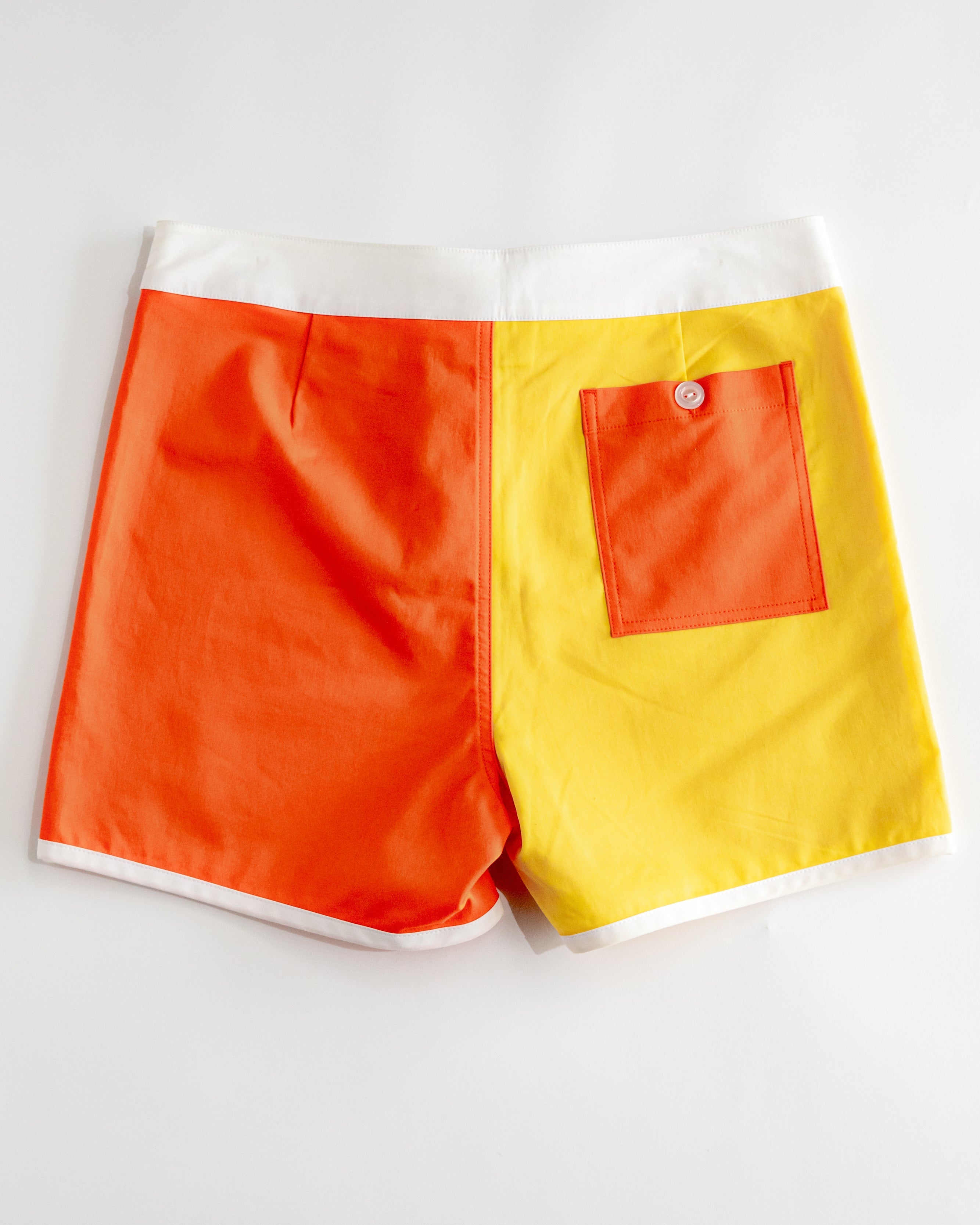 Color-blocked shorts with orange and yellow design on a white background
