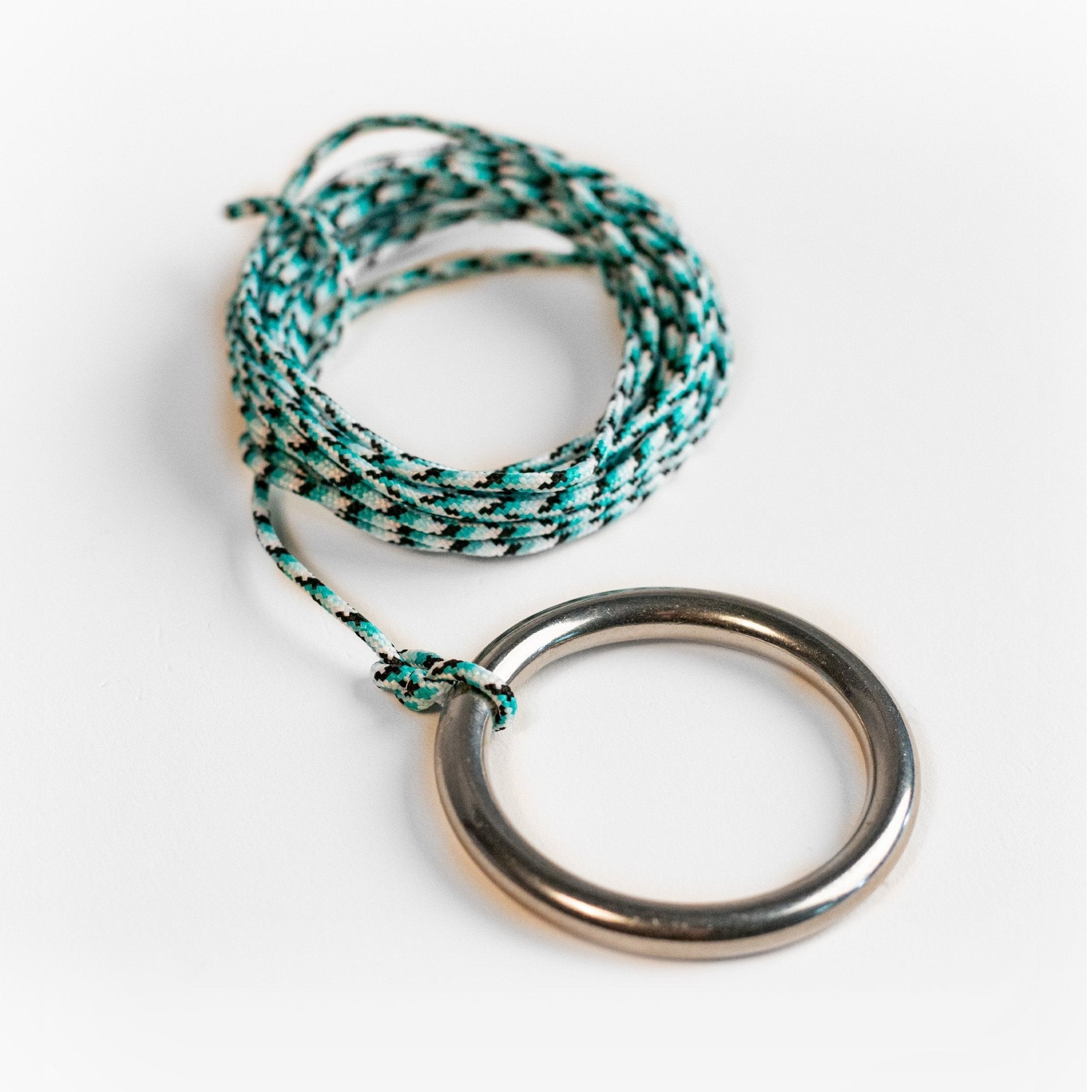 Bracelet with braided green and white cord and metal ring on a white background