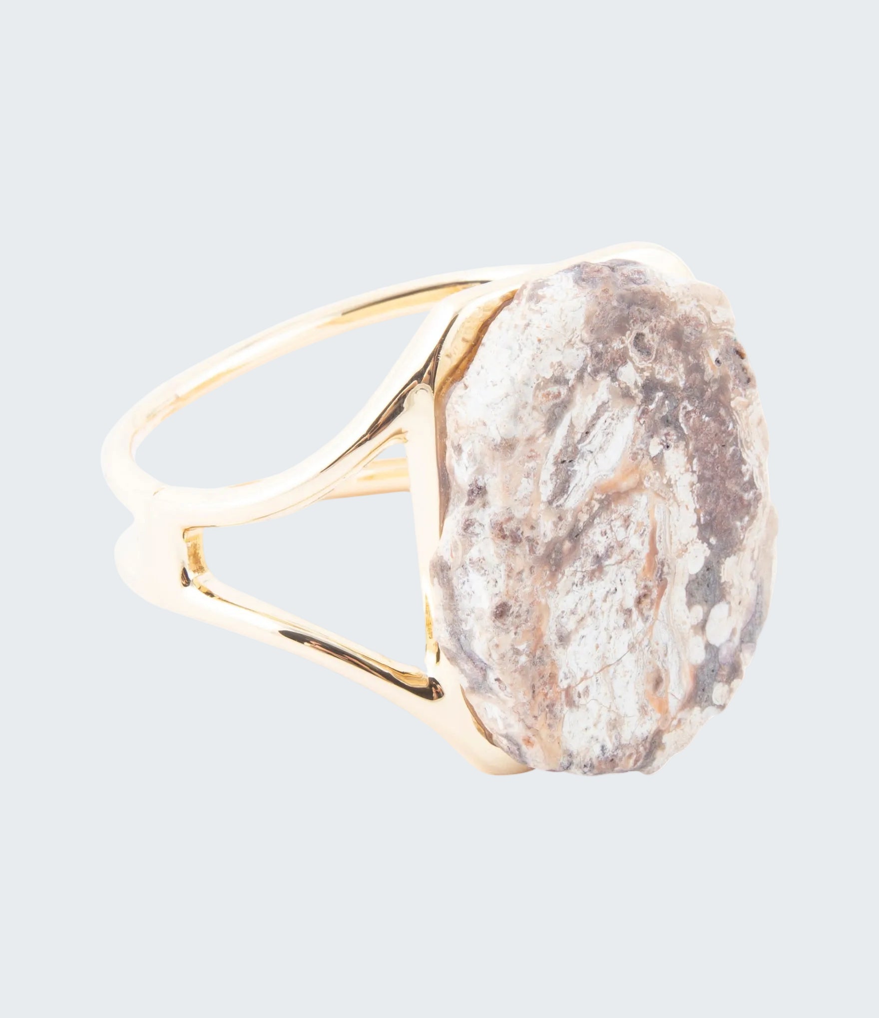 Ring with a gold band and large stone on a white background