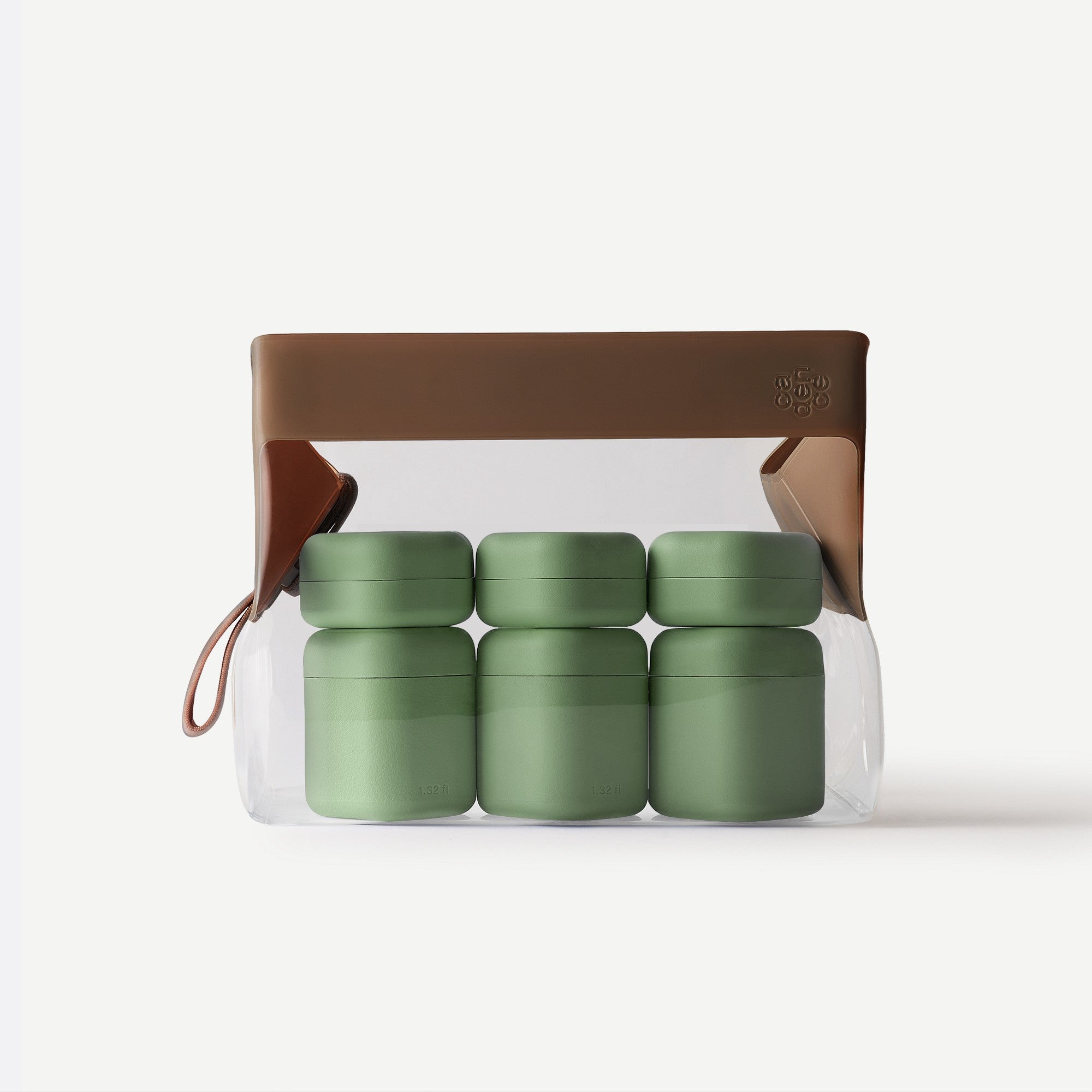 Set of green containers in a transparent plastic bag with a brown handle on a white background