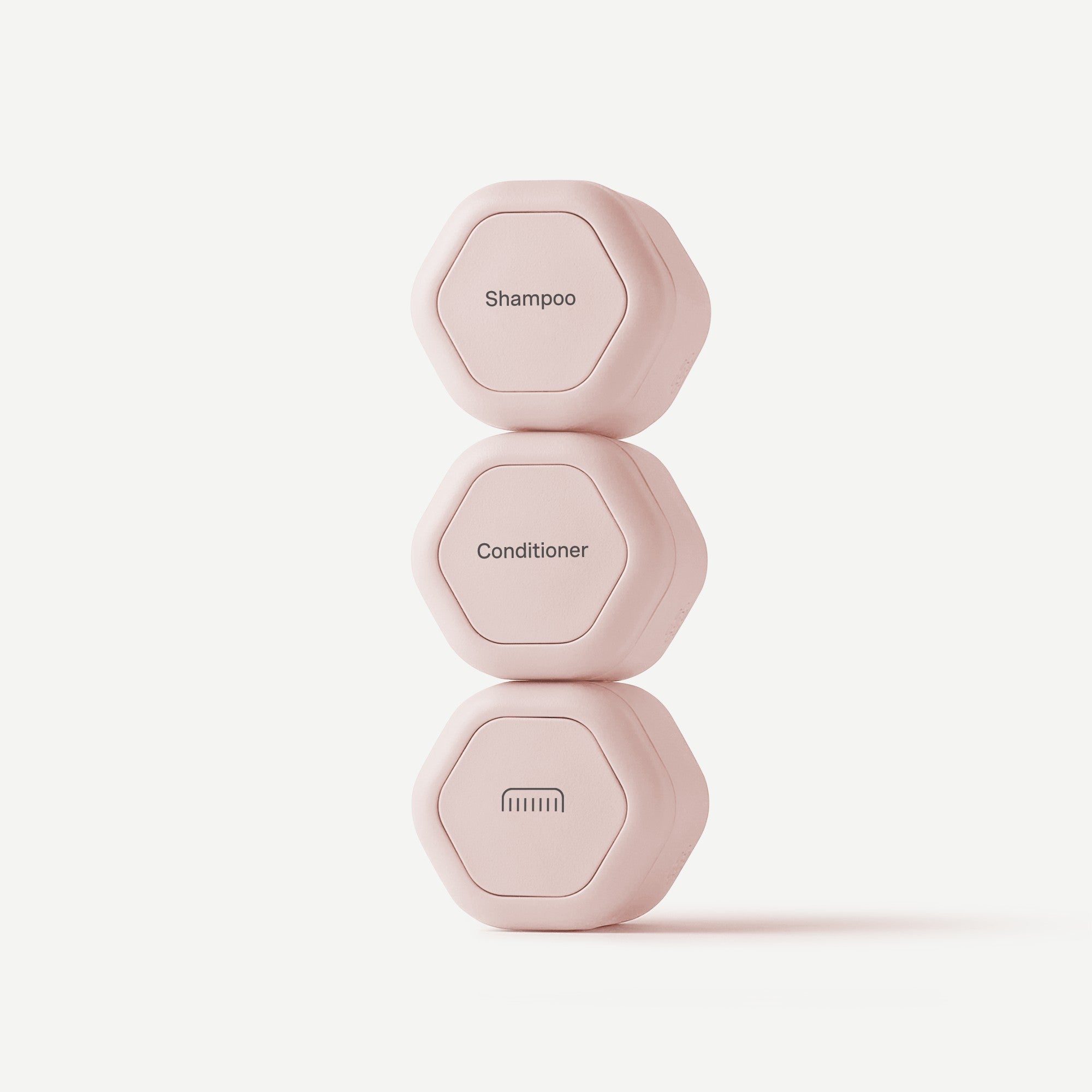 Three pink shampoo bottles labeled 'Shampoo', 'Conditioner', and 'Body Wash' on a light pink background.