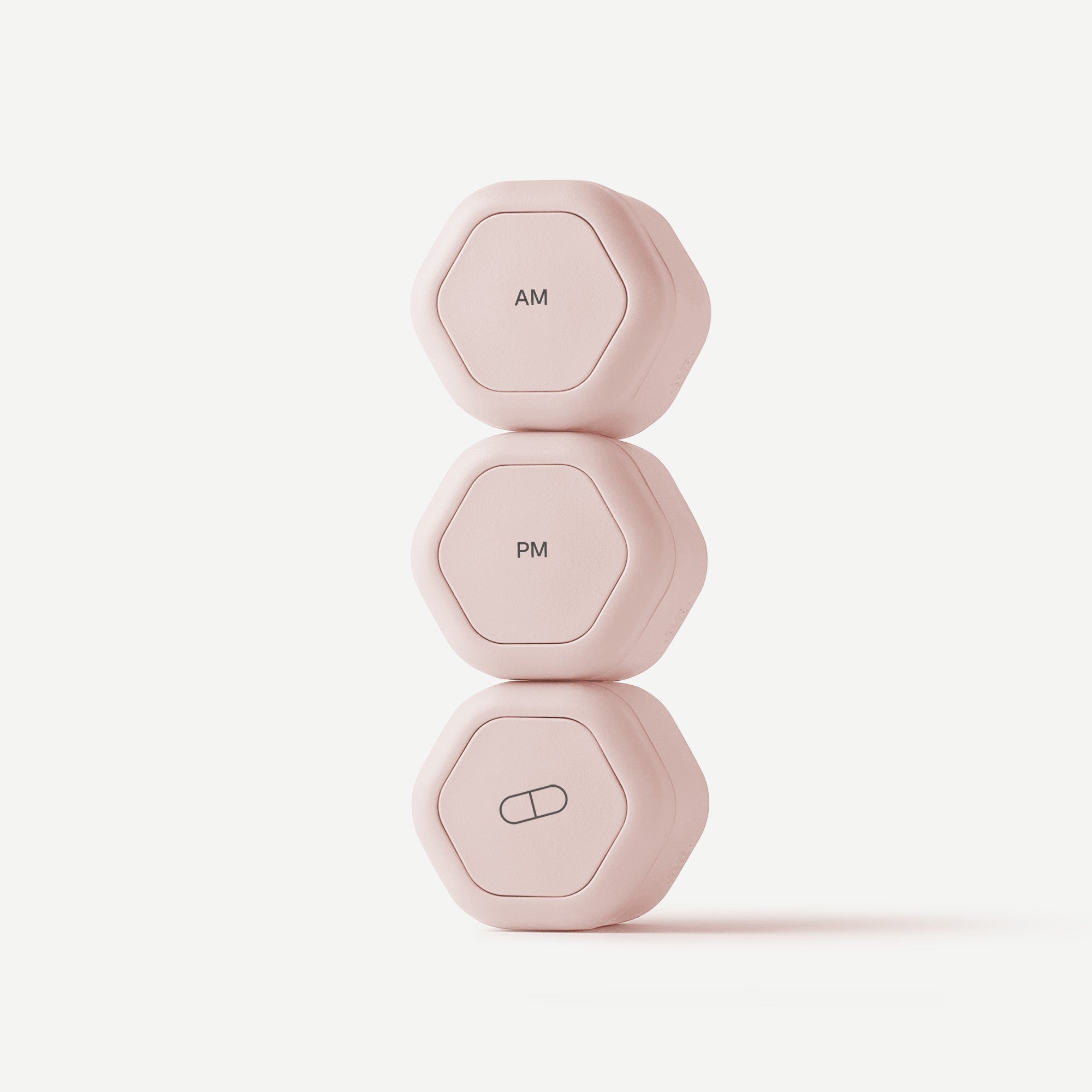 Three small hexagonal pink electronic devices stacked vertically on a clean white background, labeled AM, PM, and a capsule icon.