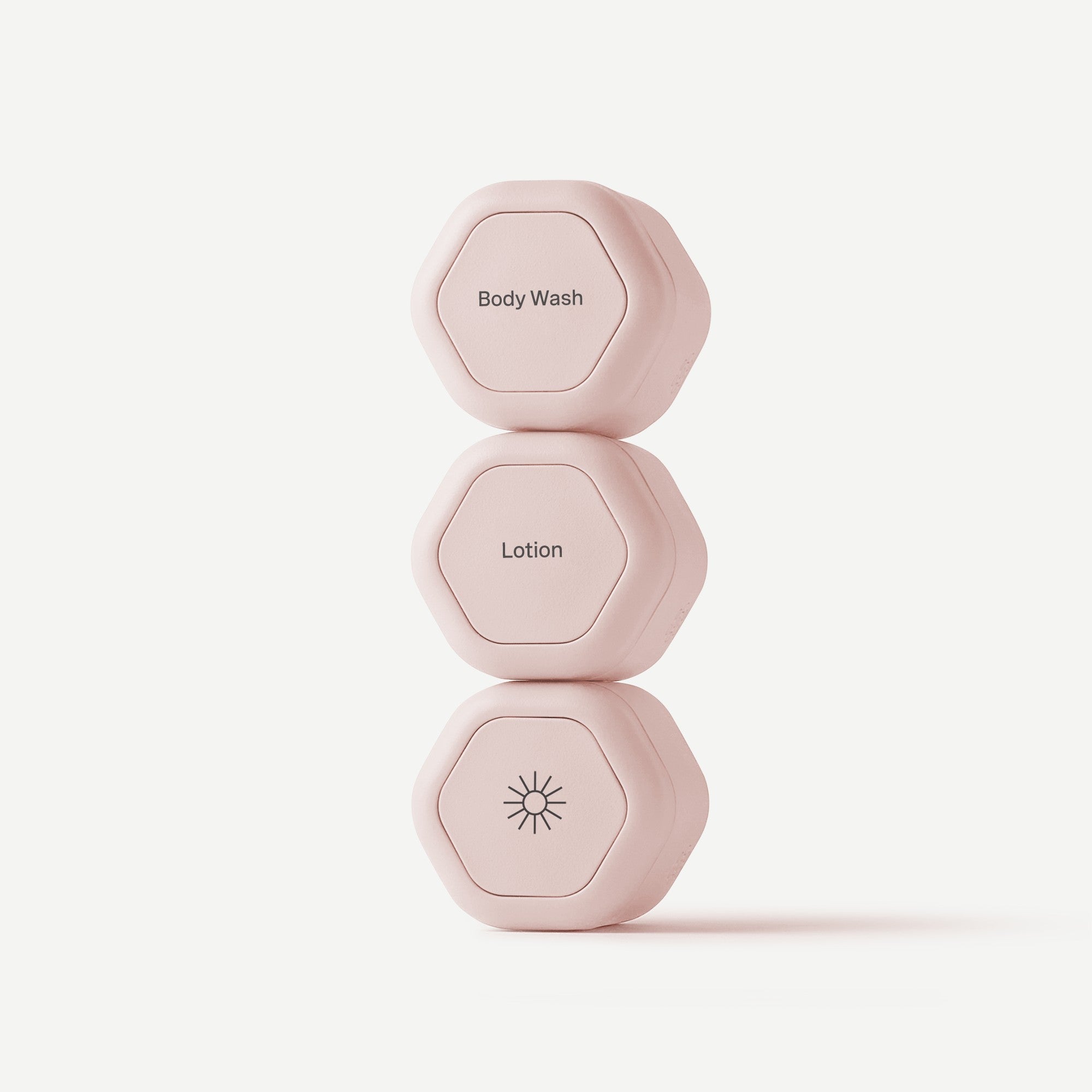 Set of three pink dumbbells on a light pink background