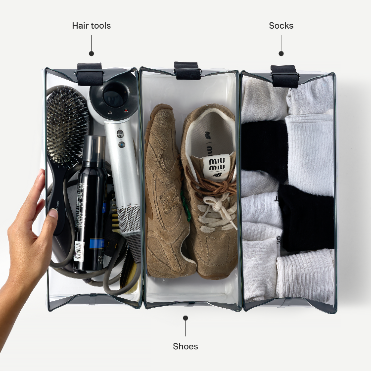 Clear travel organizer with hair tools, shoes, and socks labeled.