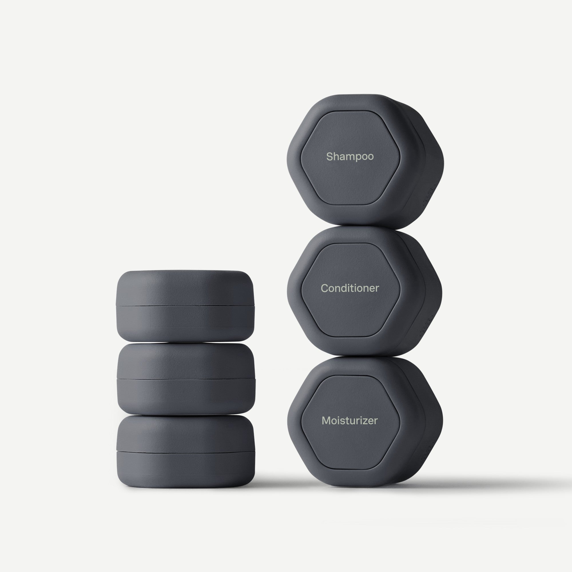 Stack of gray containers labeled 'Shampoo', 'Conditioner', and 'Moisturizer' on a white background