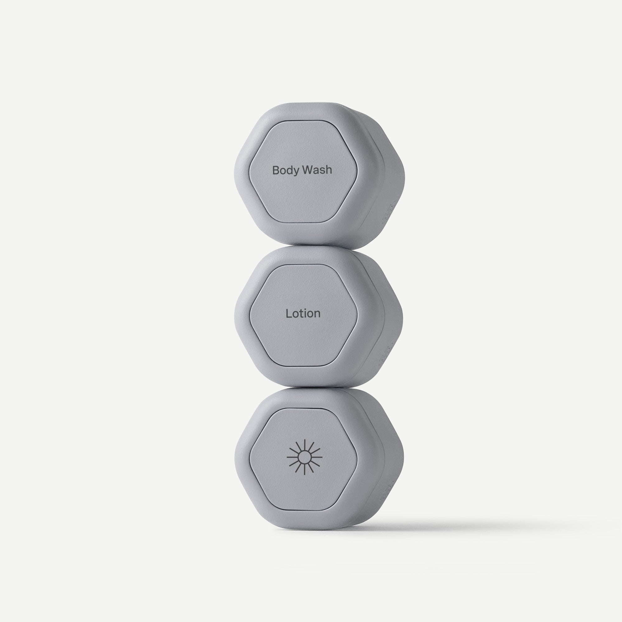 Three gray hexagonal containers labeled 'Body Wash', 'Lotion', and a sun icon on a white background.