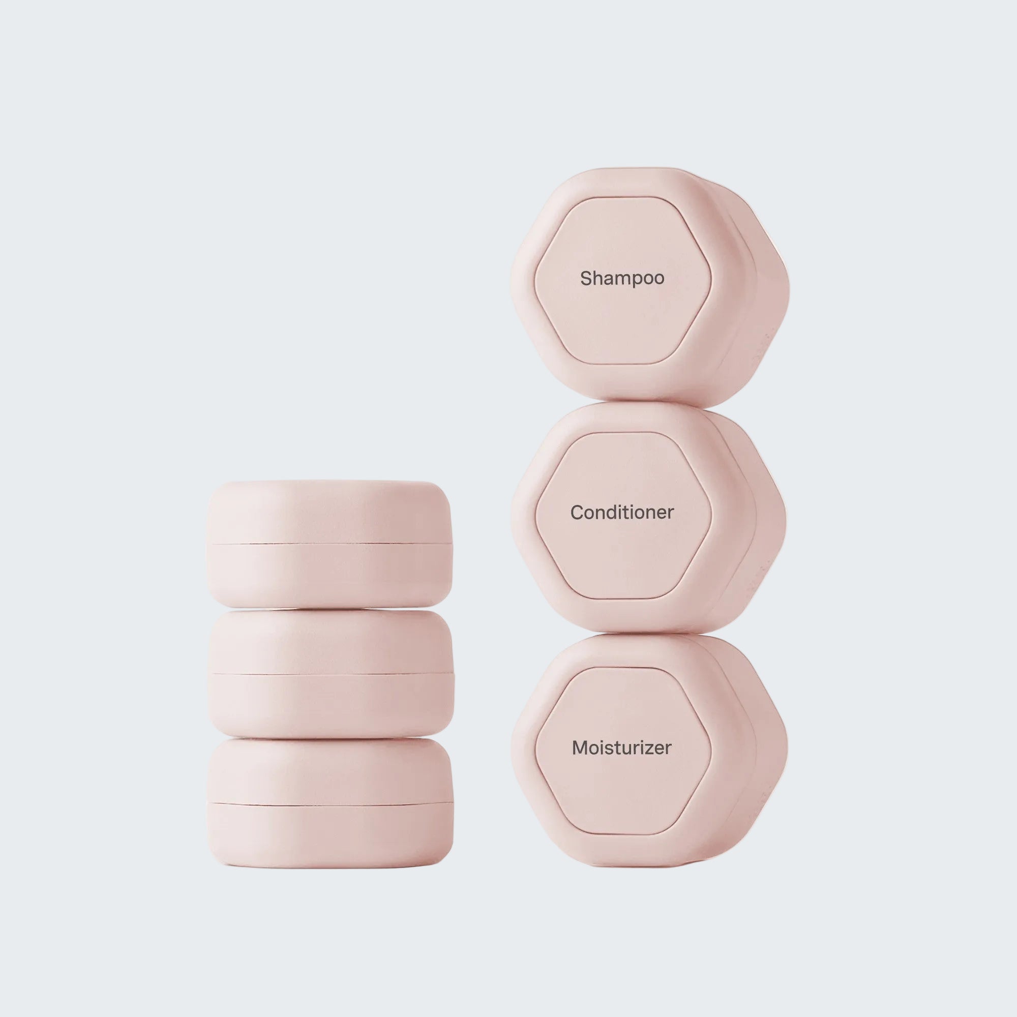 Set of pink hexagonal containers labeled 'Shampoo', 'Conditioner', and 'Moisturizer' on a white background