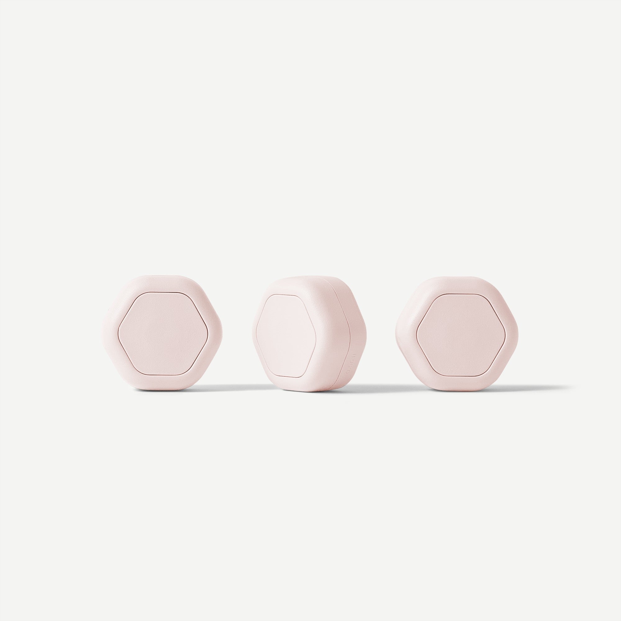Three pink hexagonal objects on a white background
