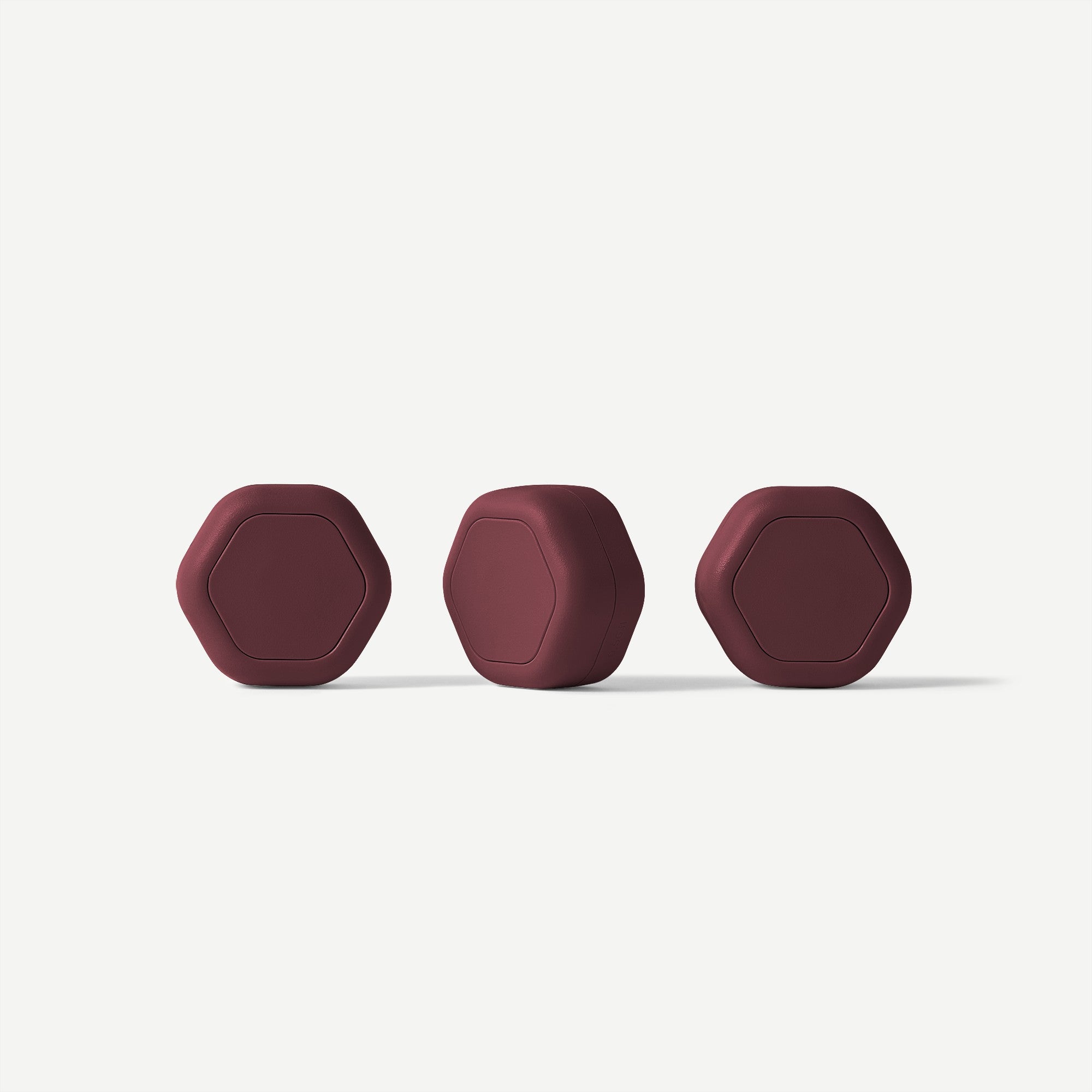 Three maroon hair care product containers on a white background