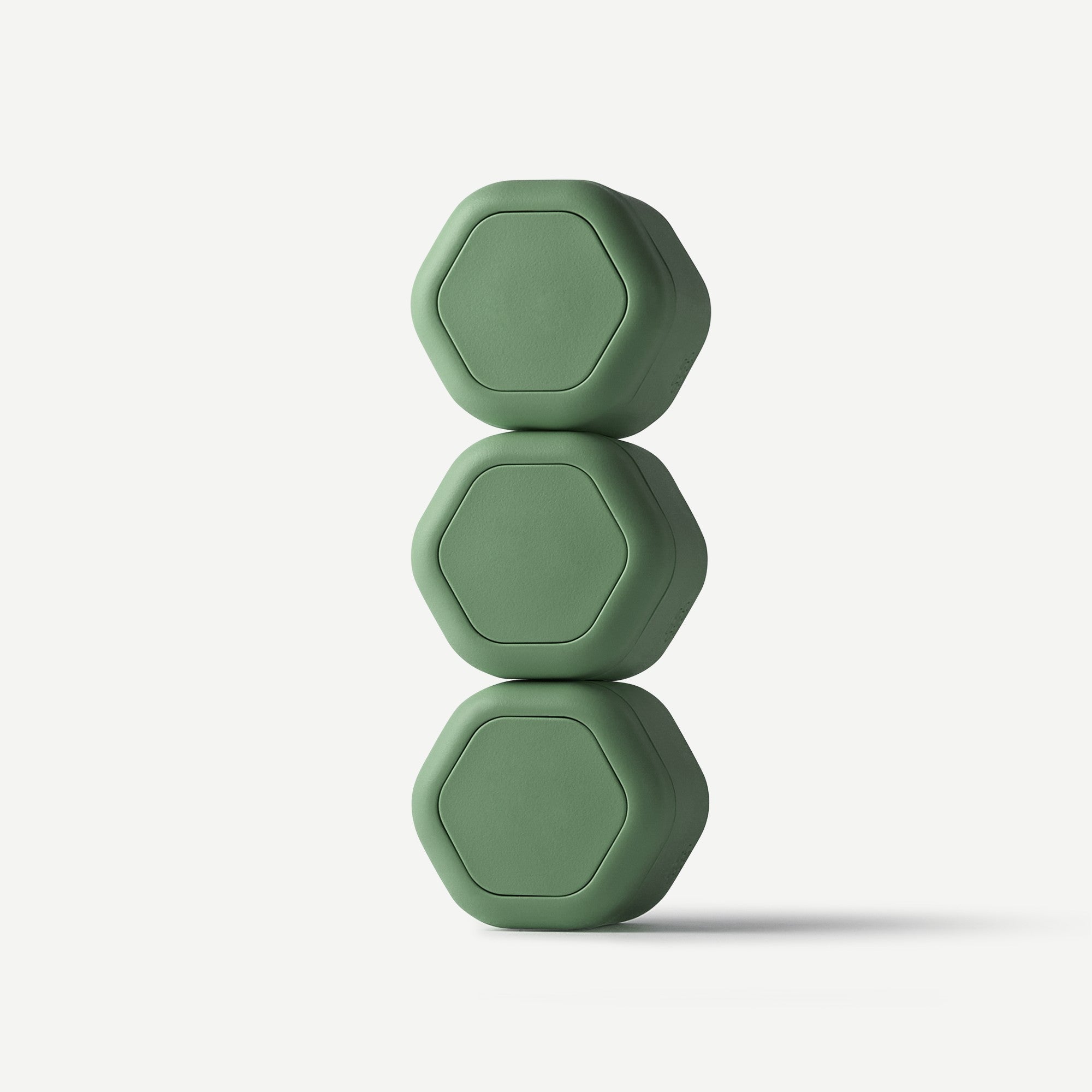 Three matching matte sage green hexagonal portable speakers stacked vertically on a clean white background.
