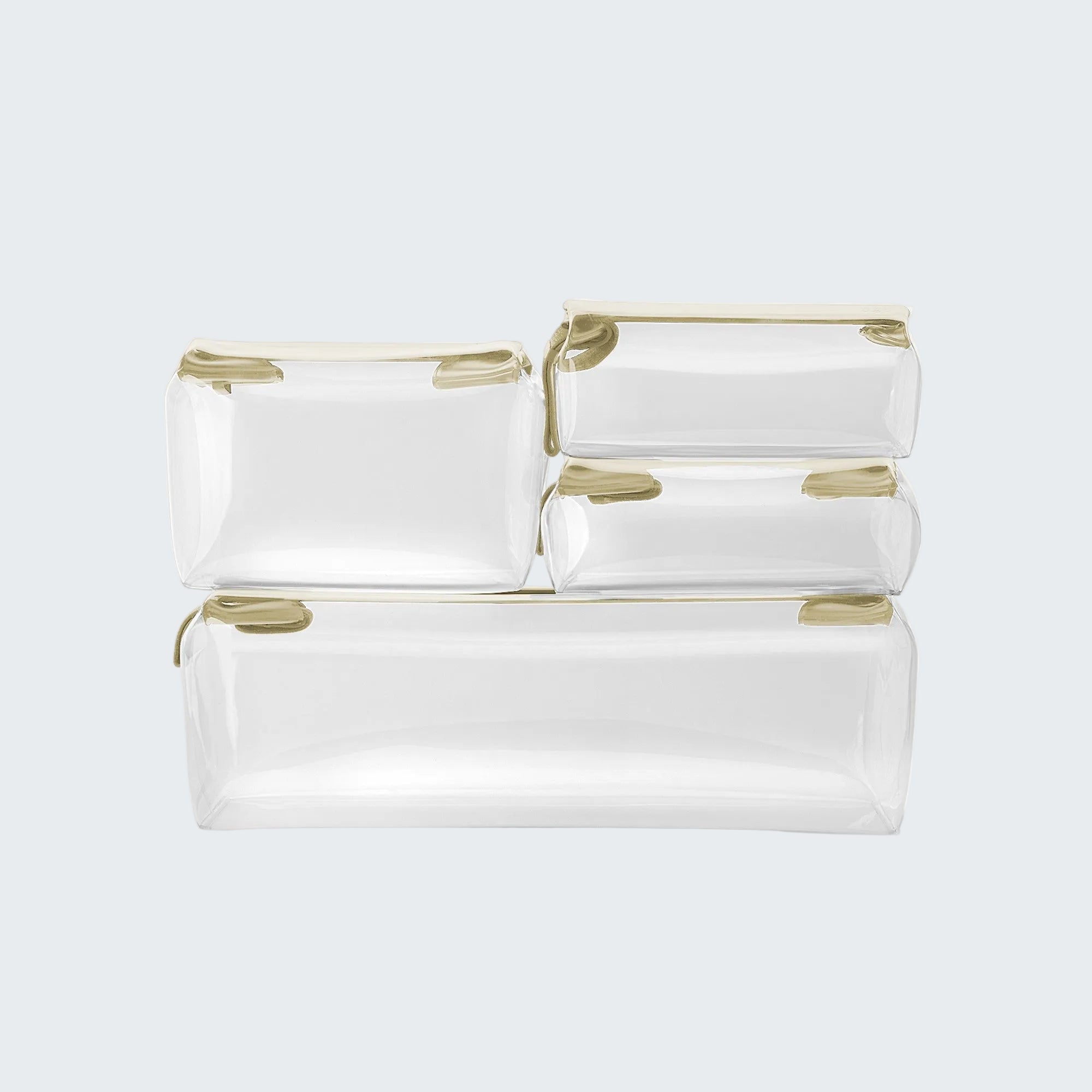 Set of white toiletry bags with gold zippers on a light gray background