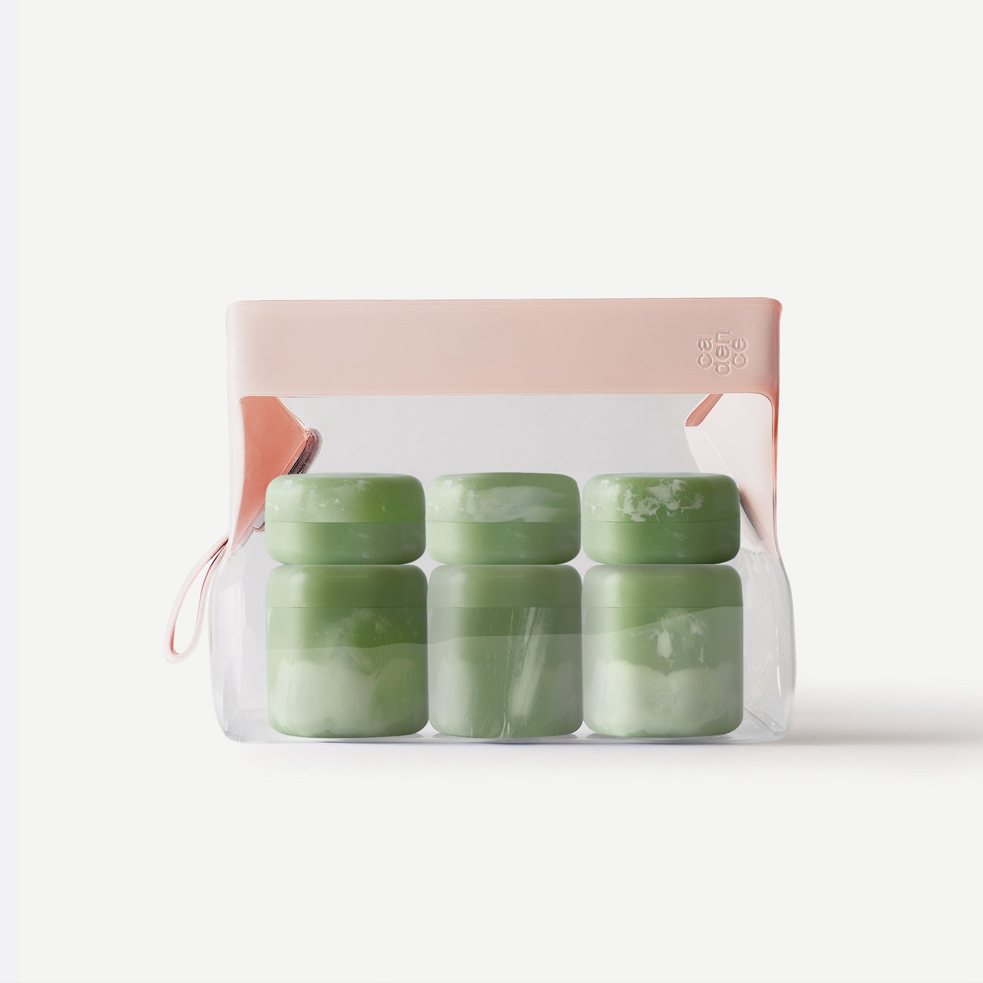 Set of green jars in a clear plastic pack with a pink lid on a white background