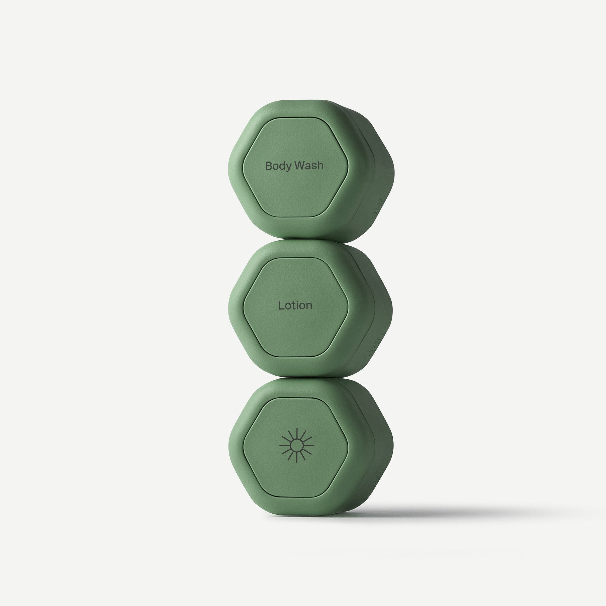 Three stacked hexagonal green containers labeled Body Wash, Lotion, and Sun, shown on a clean light gray background.