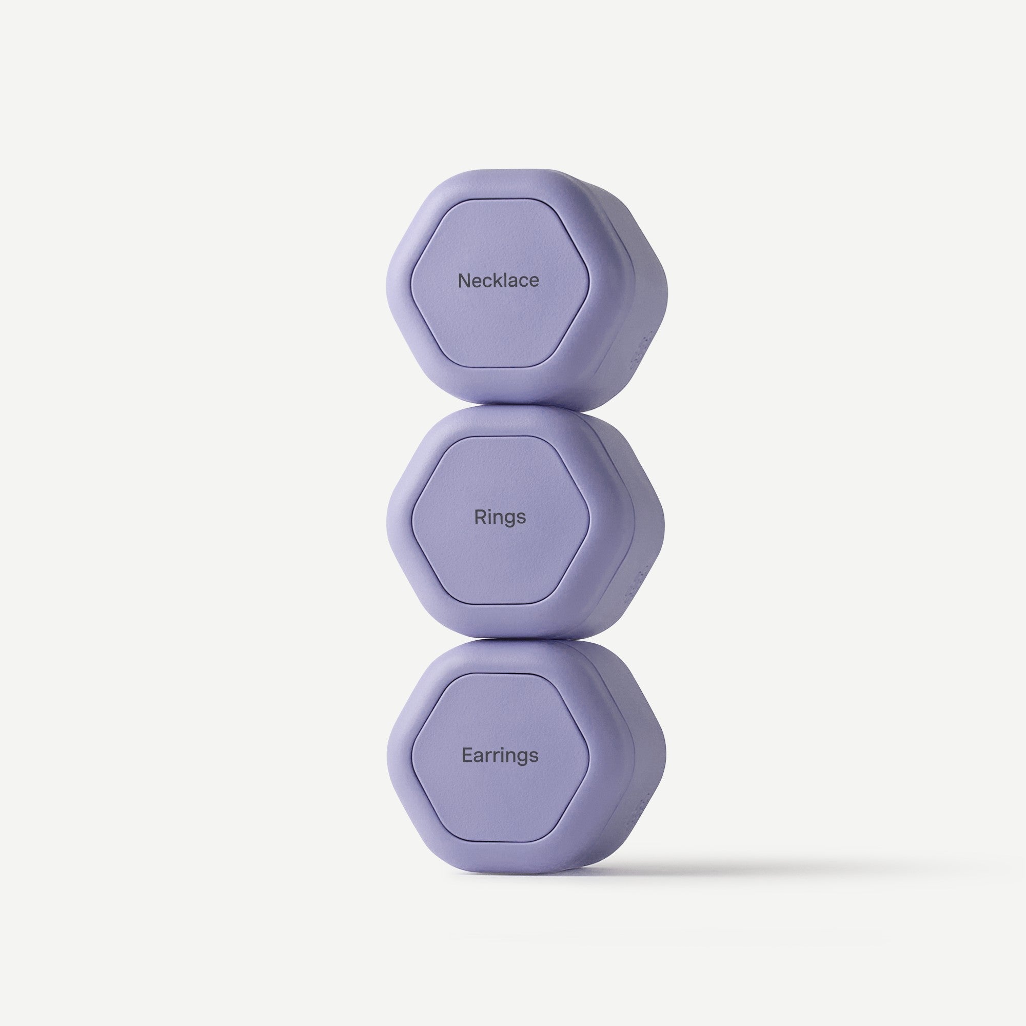 Three lavender hexagonal jewelry organizer capsules stacked vertically on a light gray background. The top capsule is labeled 'Necklace', the middle 'Rings', and the bottom 'Earrings'.