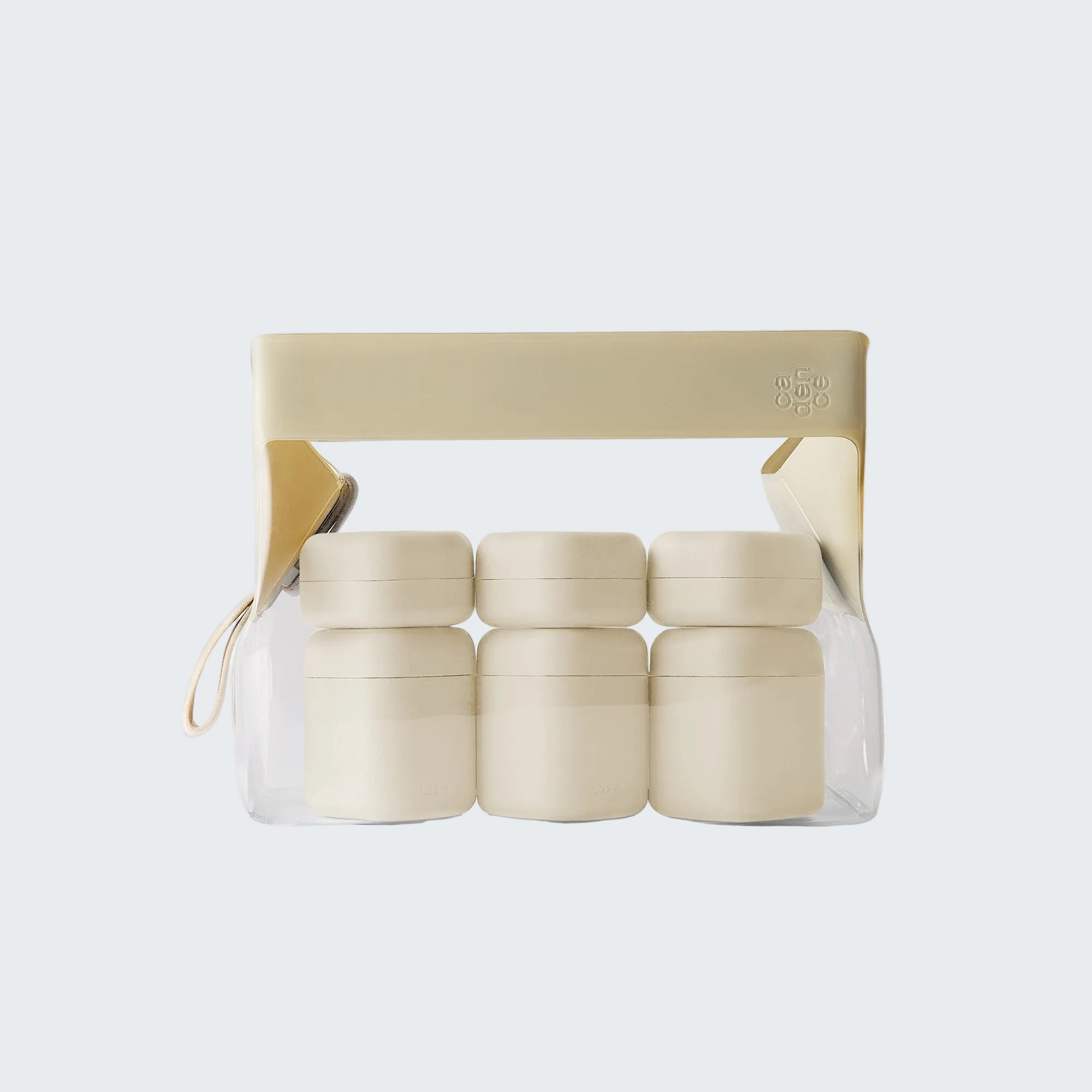Set of four small beige jars in a clear plastic package with a beige lid on a white background.