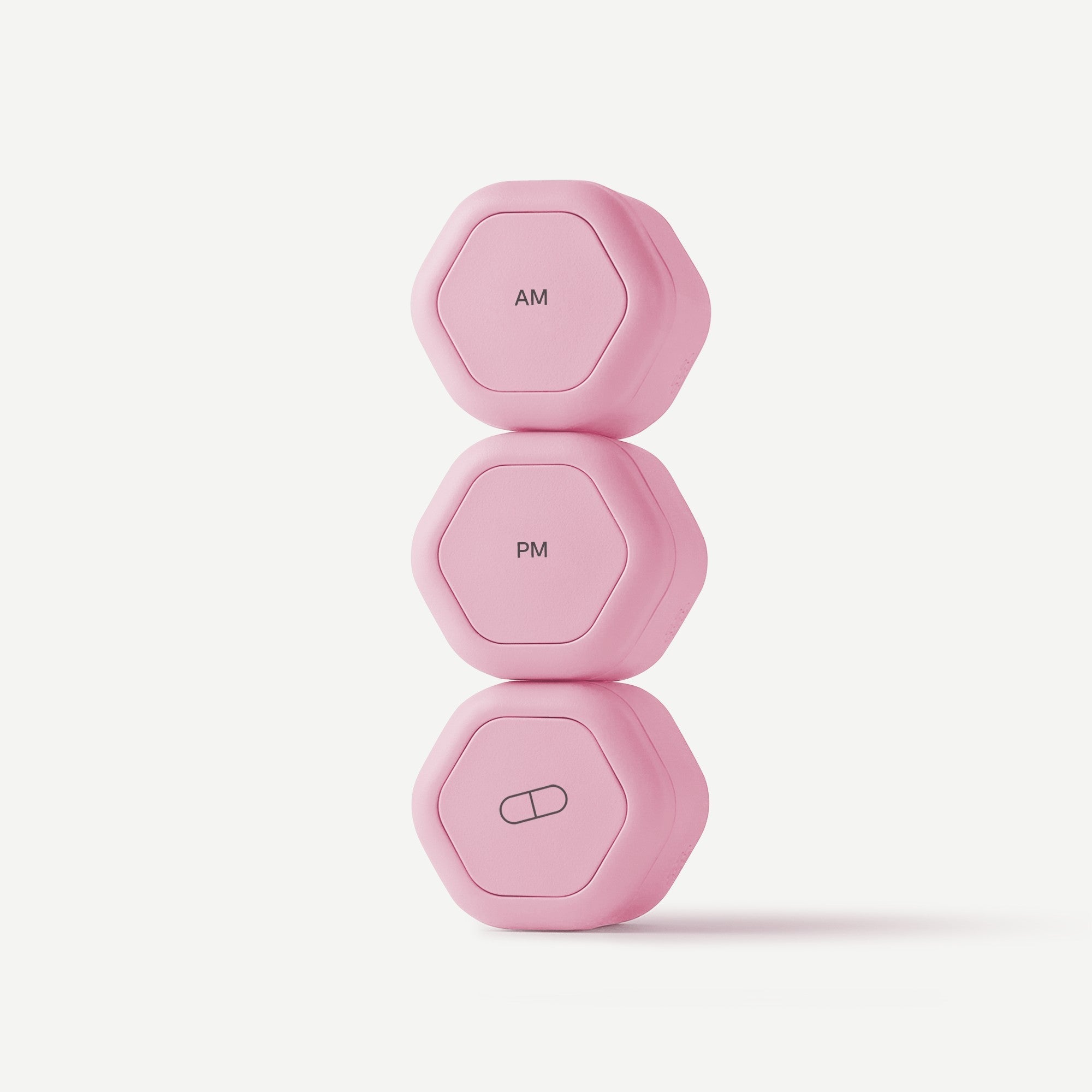 Set of three pink dumbbells on a light pink background