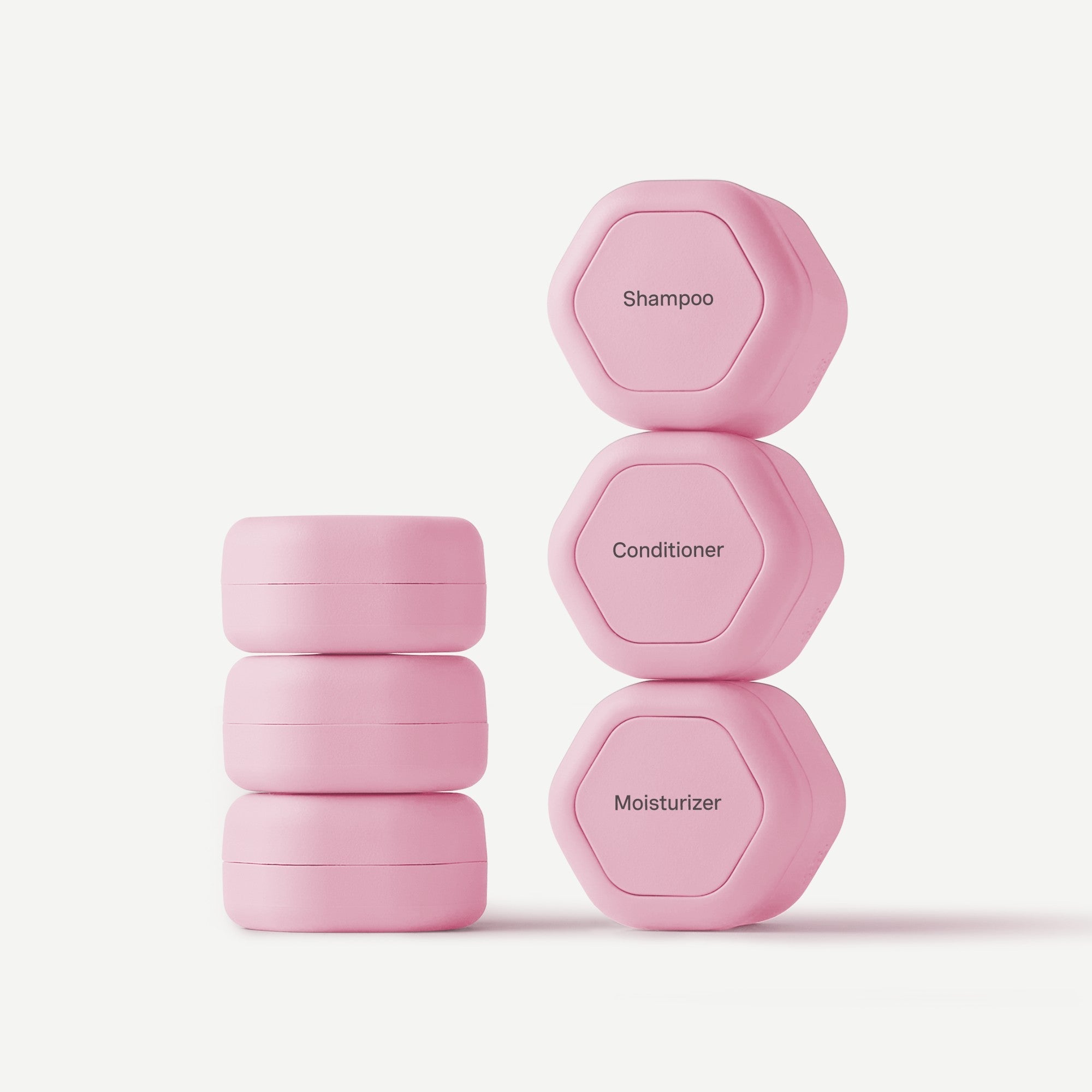 Set of pink hexagonal containers labeled 'Shampoo', 'Conditioner', and 'Moisturizer' on a white background