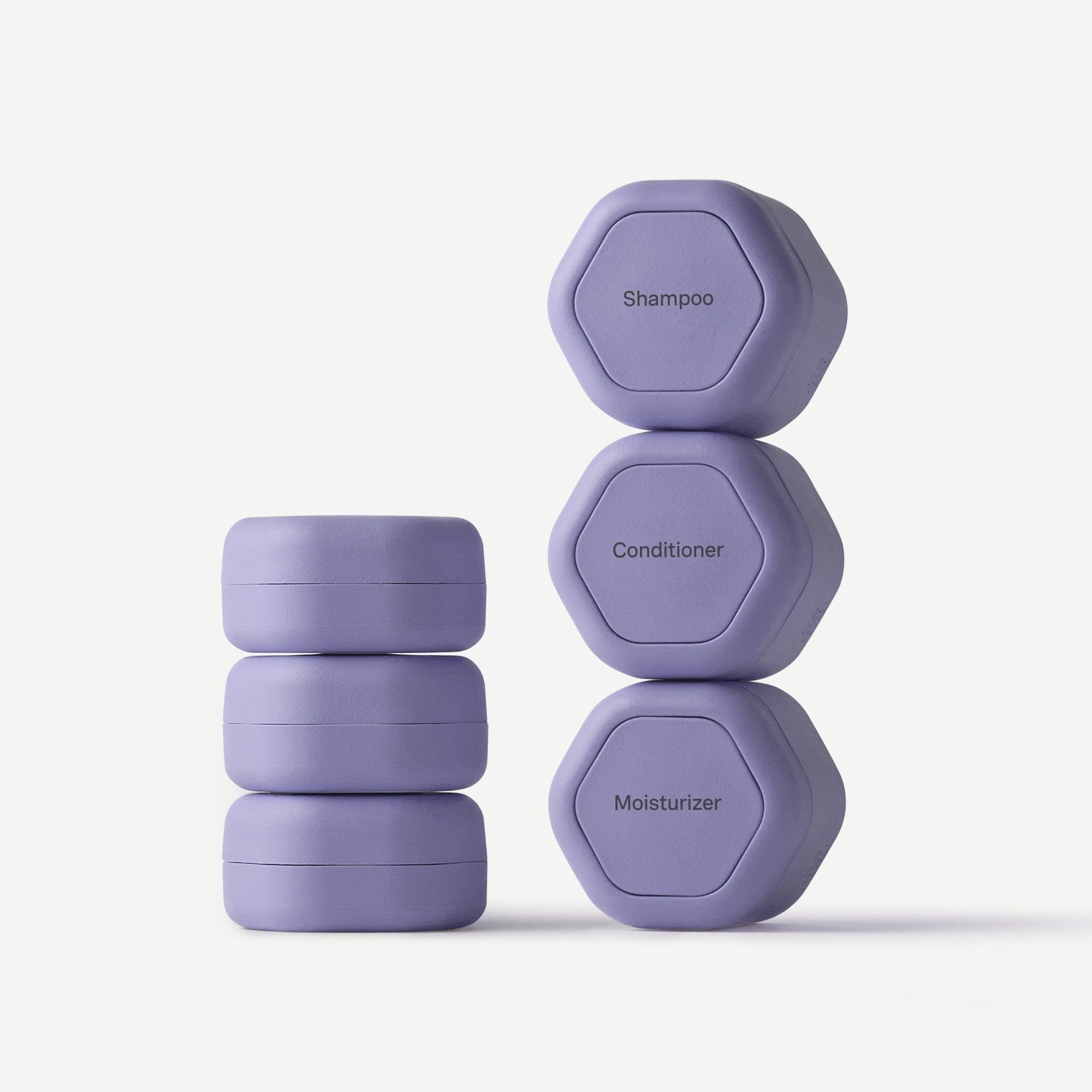 Set of purple hexagonal containers labeled 'Shampoo', 'Conditioner', and 'Moisturizer' on a white background