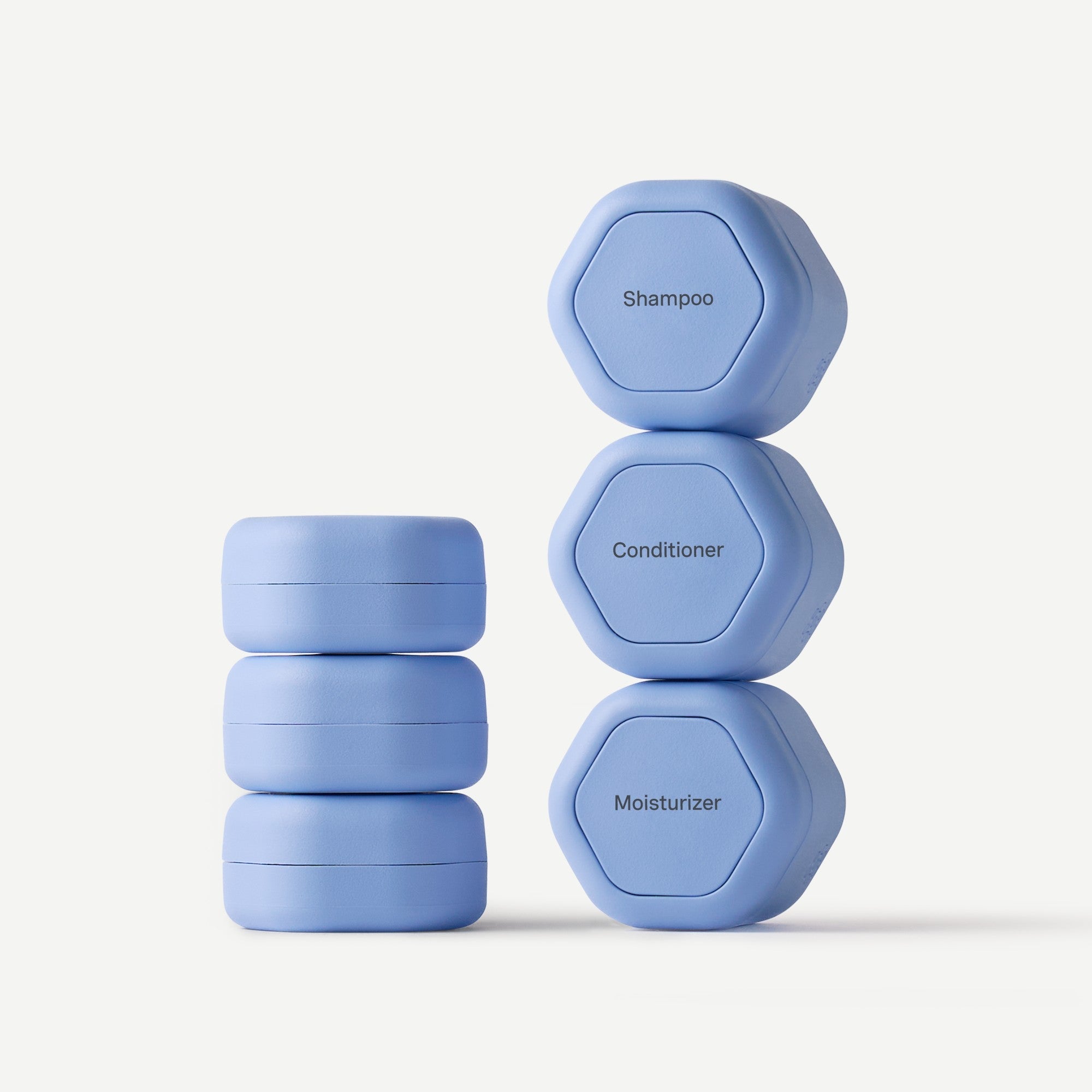 Set of blue containers labeled 'Shampoo', 'Conditioner', and 'Moisturizer' on a white background