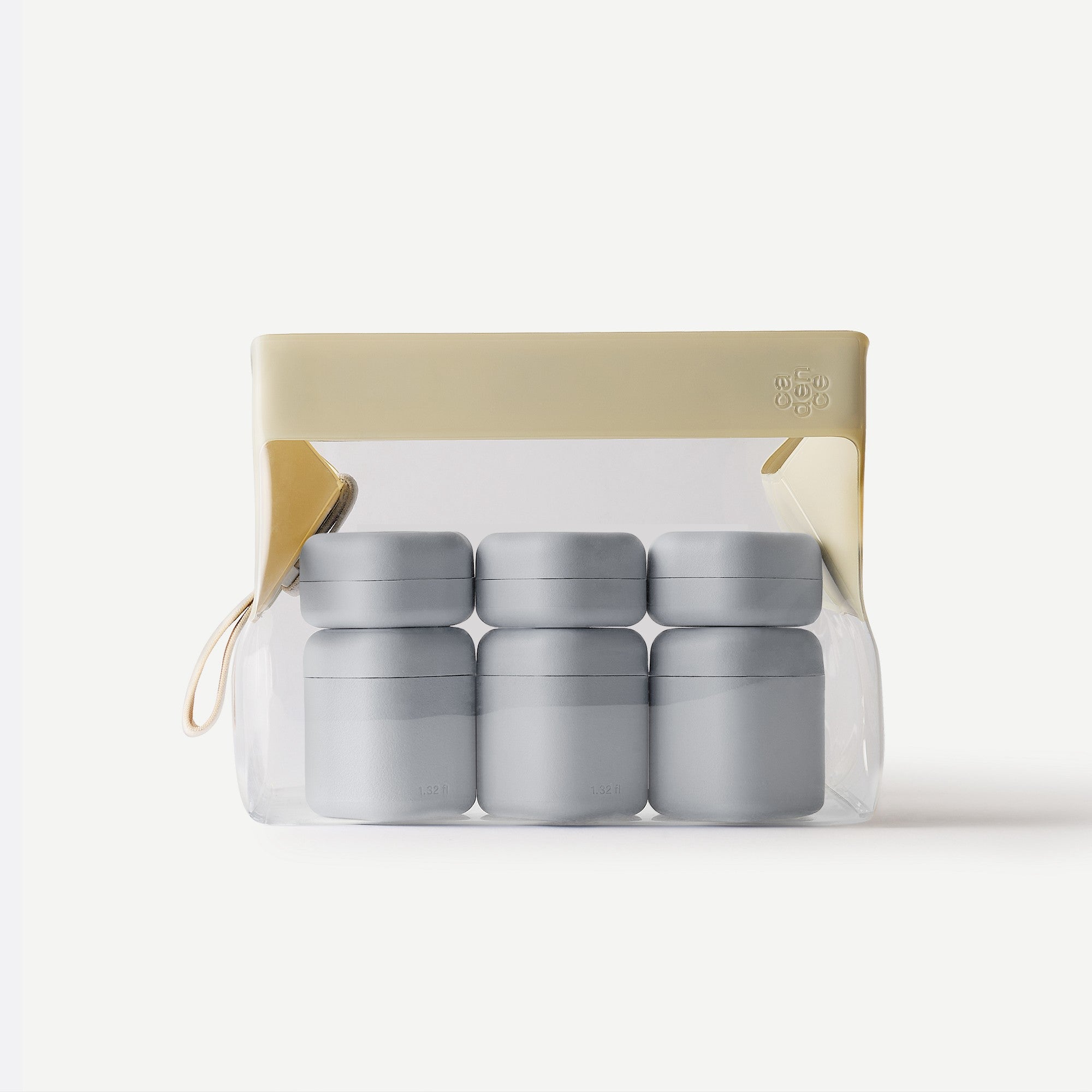 Set of four gray jars in a clear packaging with beige lid on a white background