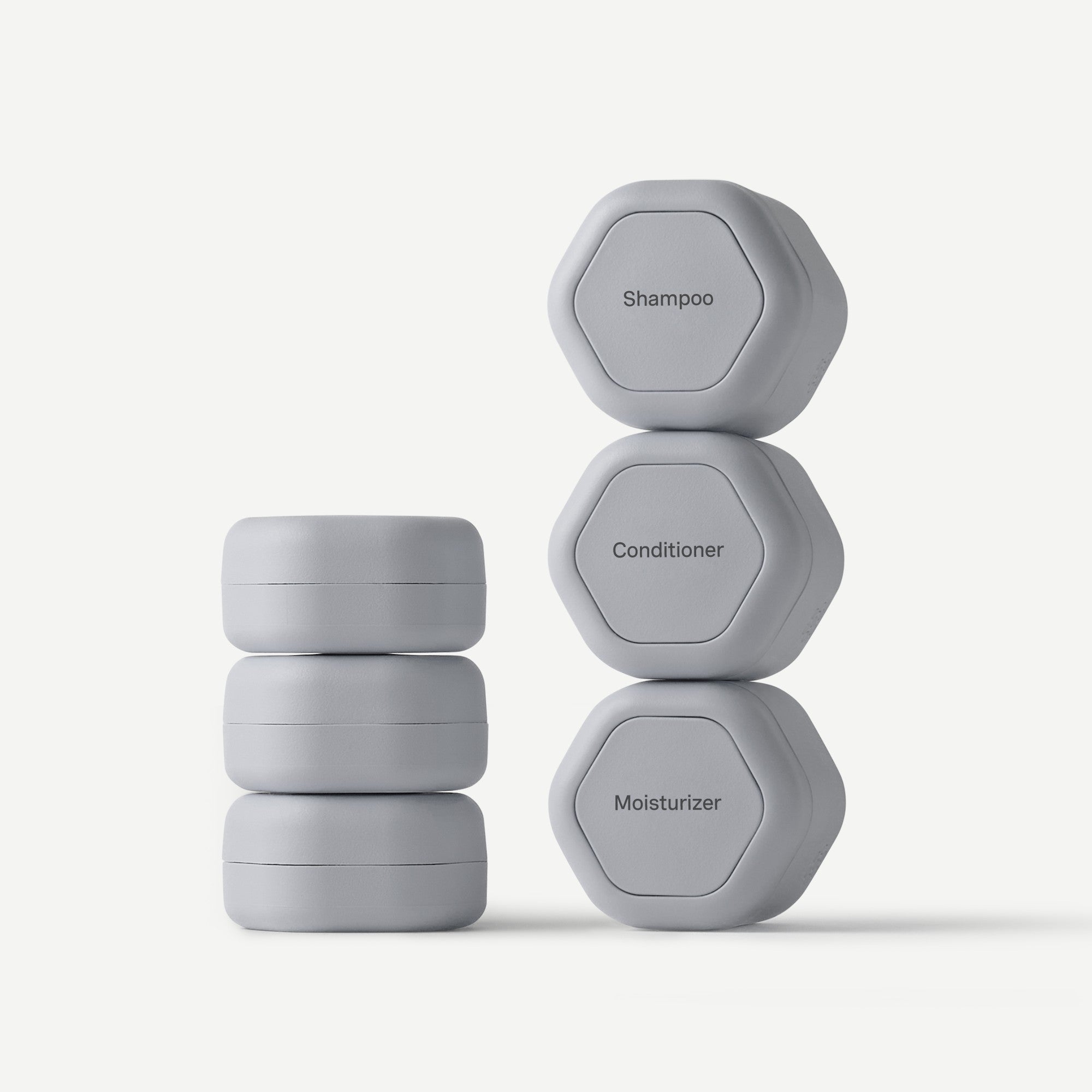 Set of gray containers labeled 'Shampoo', 'Conditioner', and 'Moisturizer' on a white background