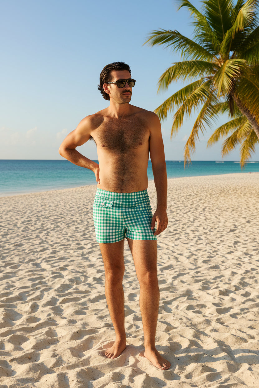 Man wearing green checkered swim shorts on a white background