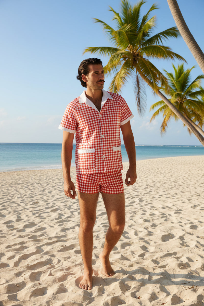 Man wearing a red and white checkered shirt and shorts on a white background