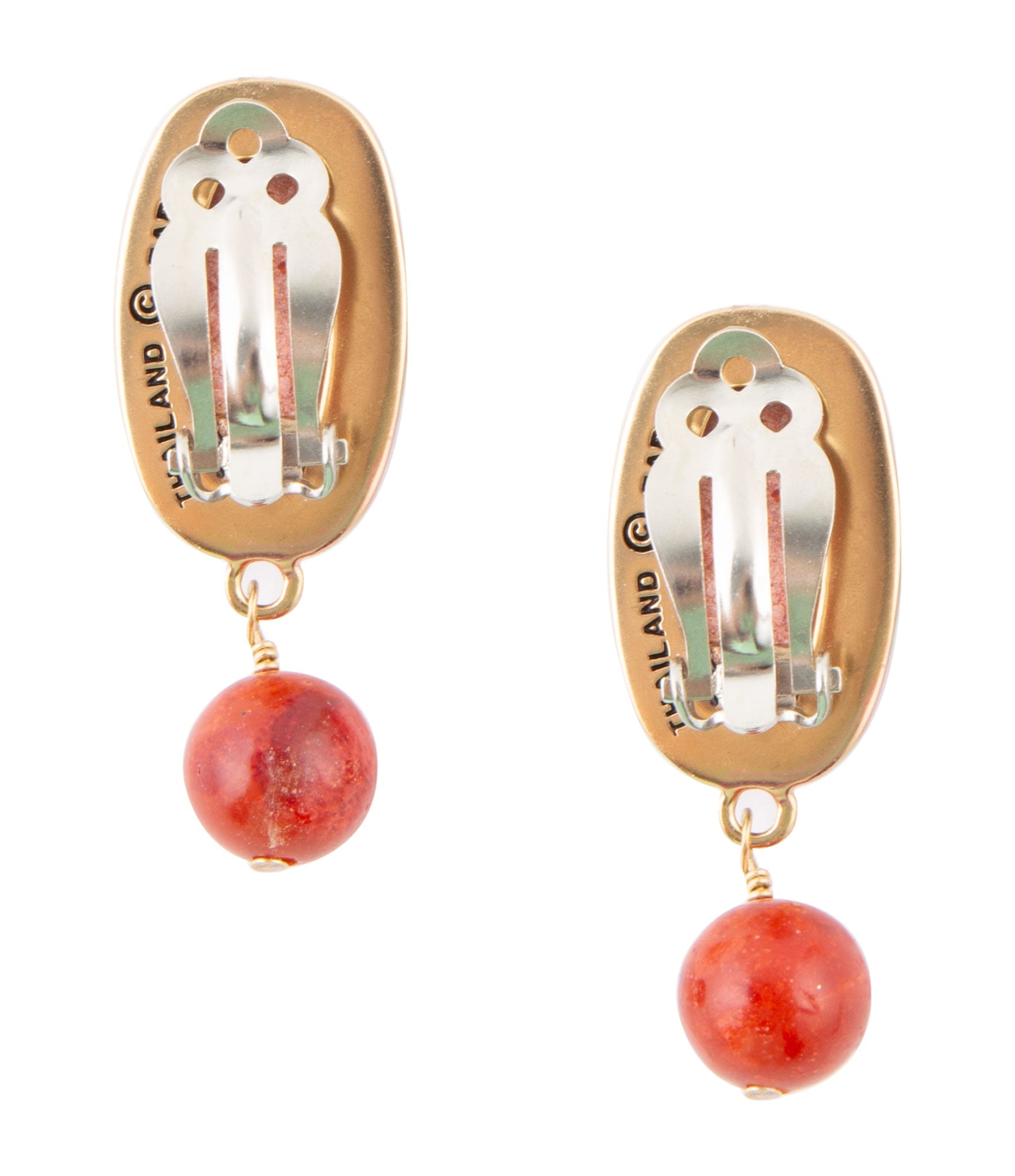 Gold earrings with red spherical beads on a white background